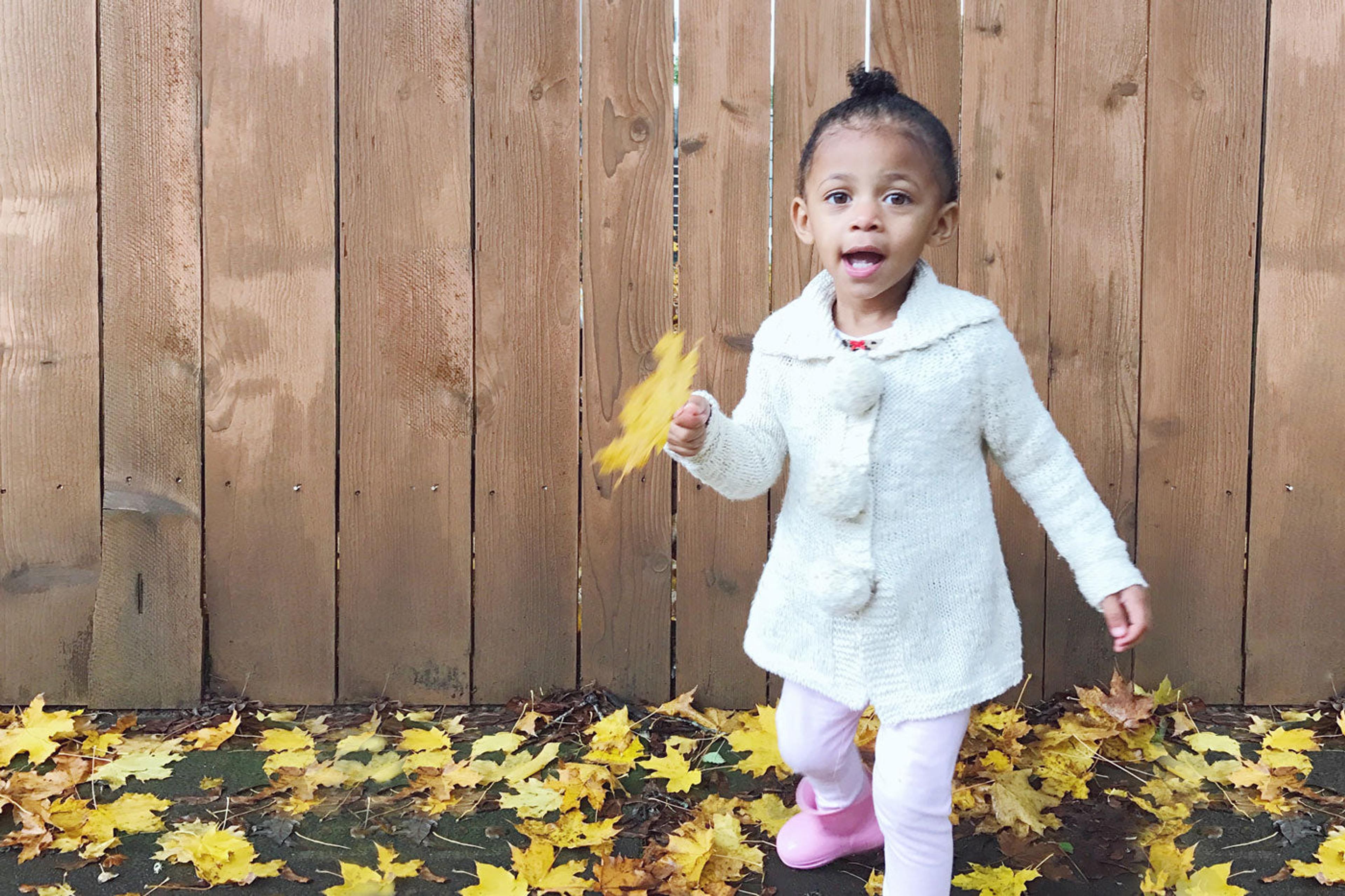 little-girl-playing-with-leaves-in-the-fall