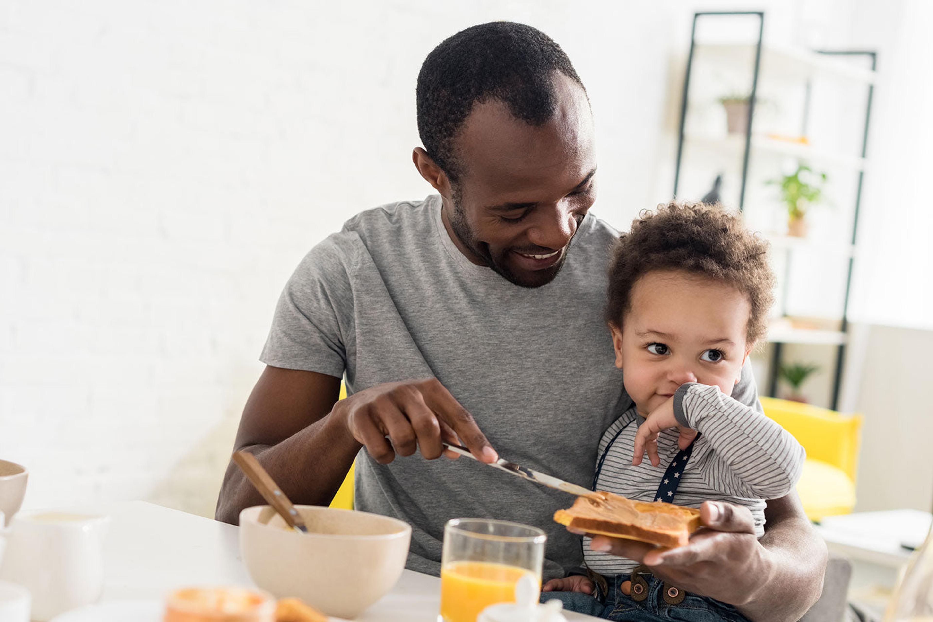 dad feeding baby peanut butter toast