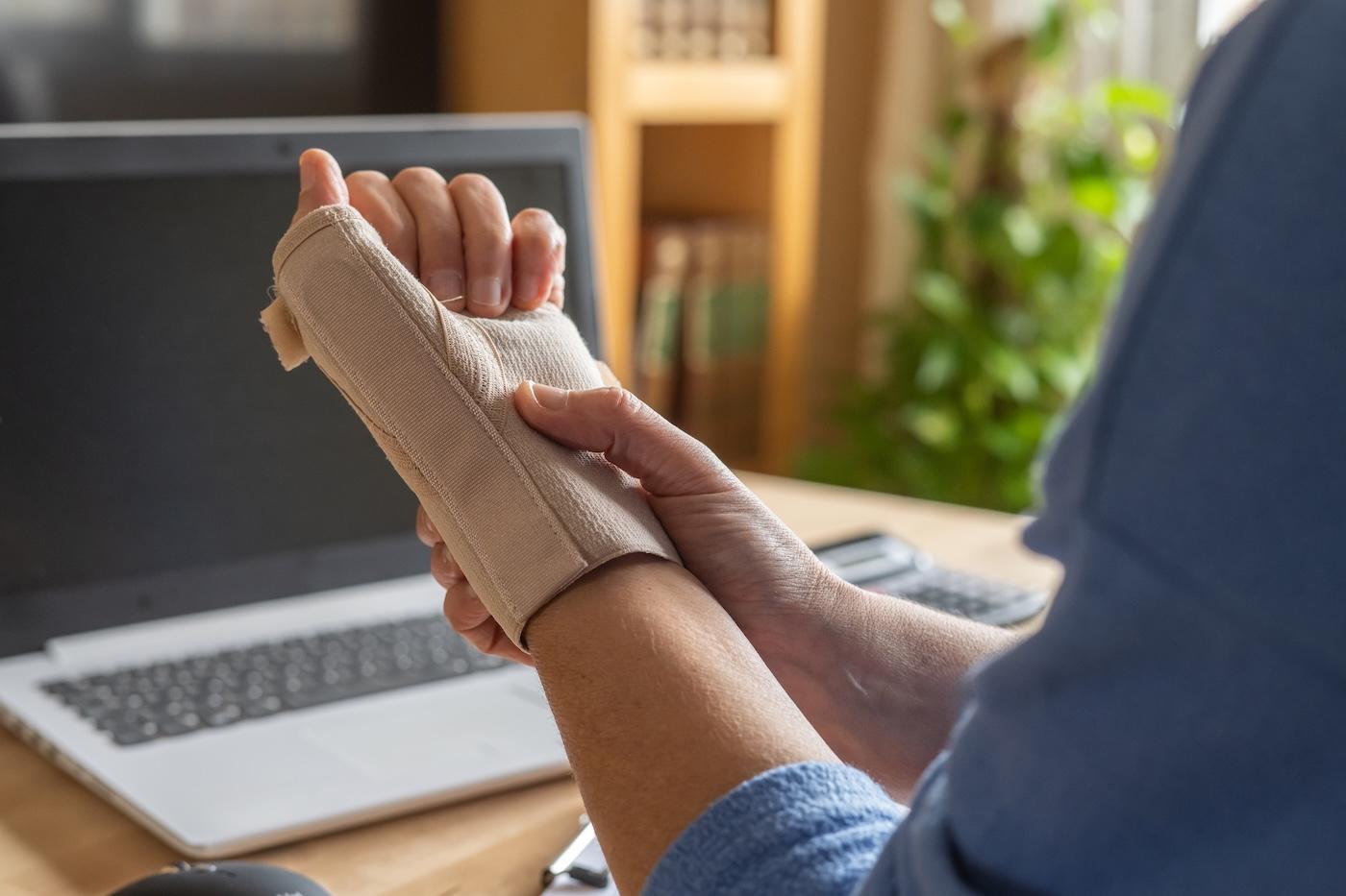 A pregnant woman wears a wrist brace for carpal tunnel syndrome