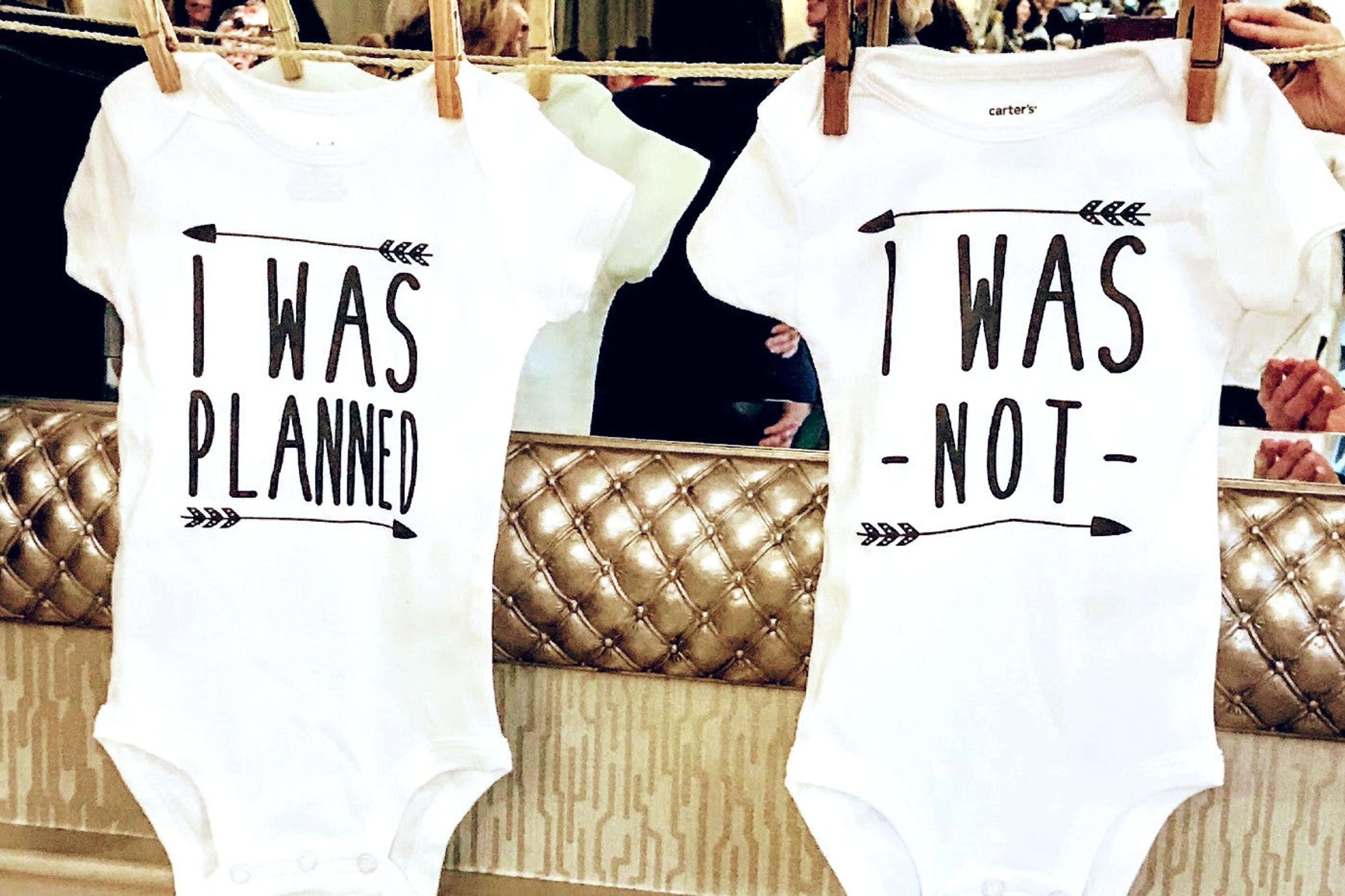Baby onesies that say "I was planned" and "I was not" to announce a twin pregnancy