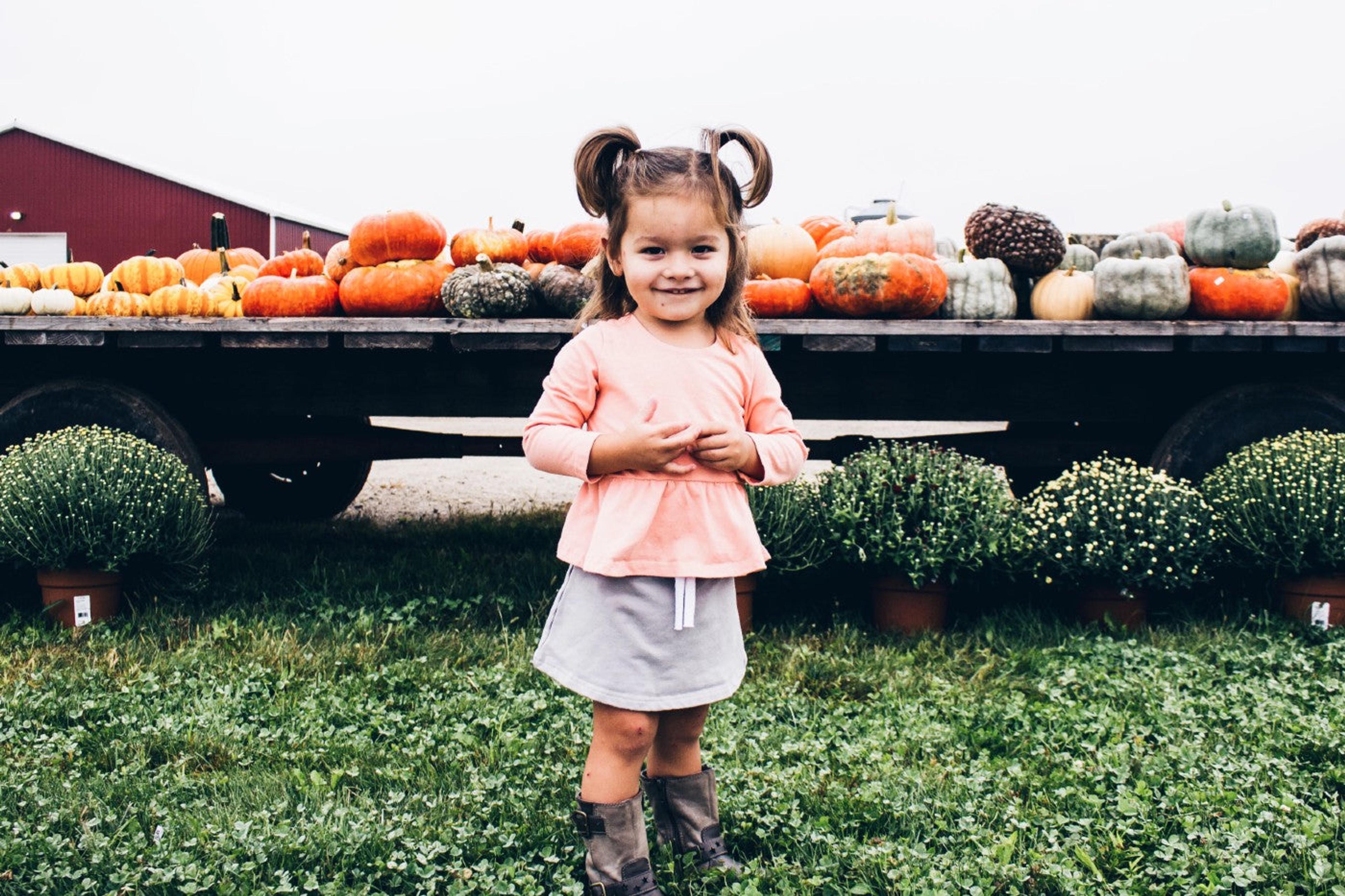 toddler-with-pumpkins-during-fall