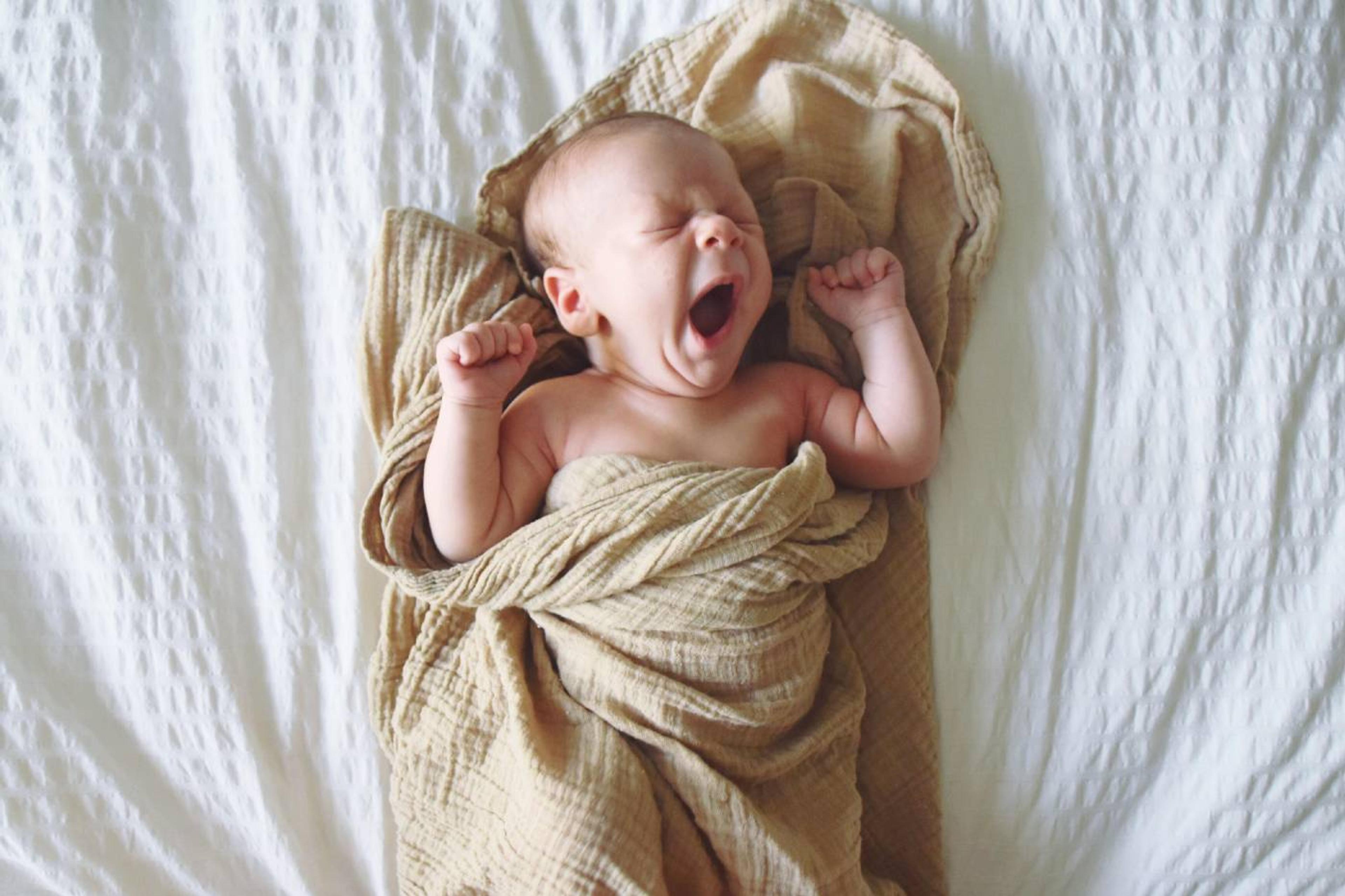 A 3-week-old baby stretches and yawns