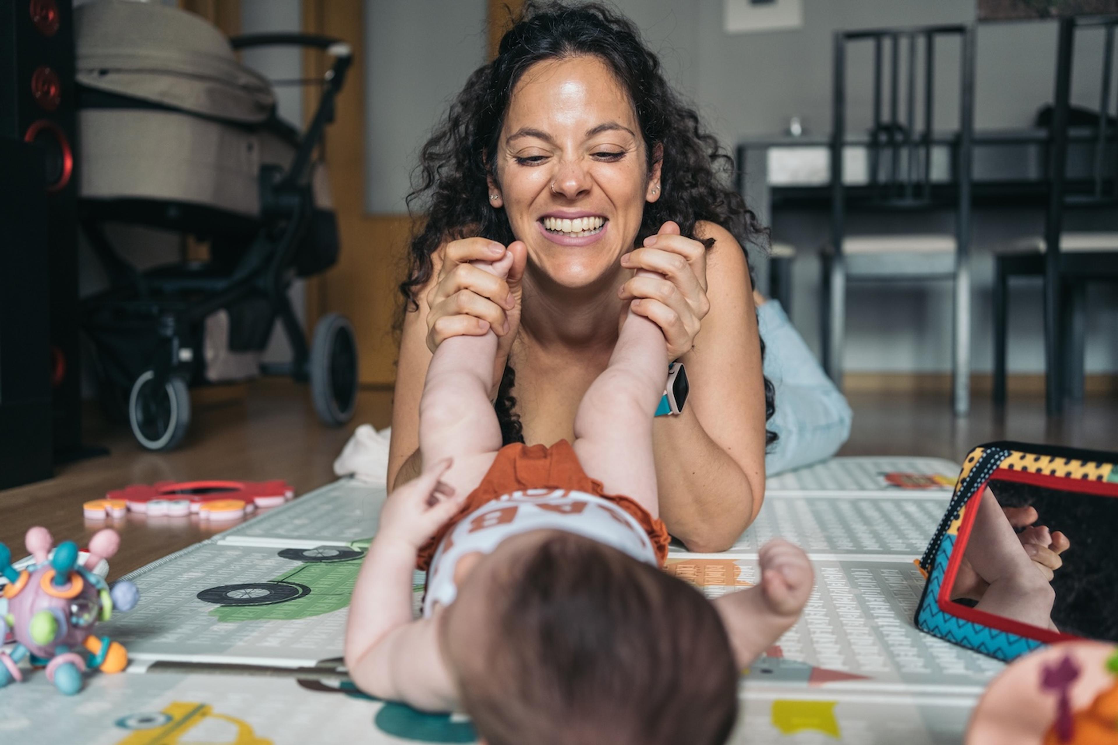 A mom plays with her newborn baby