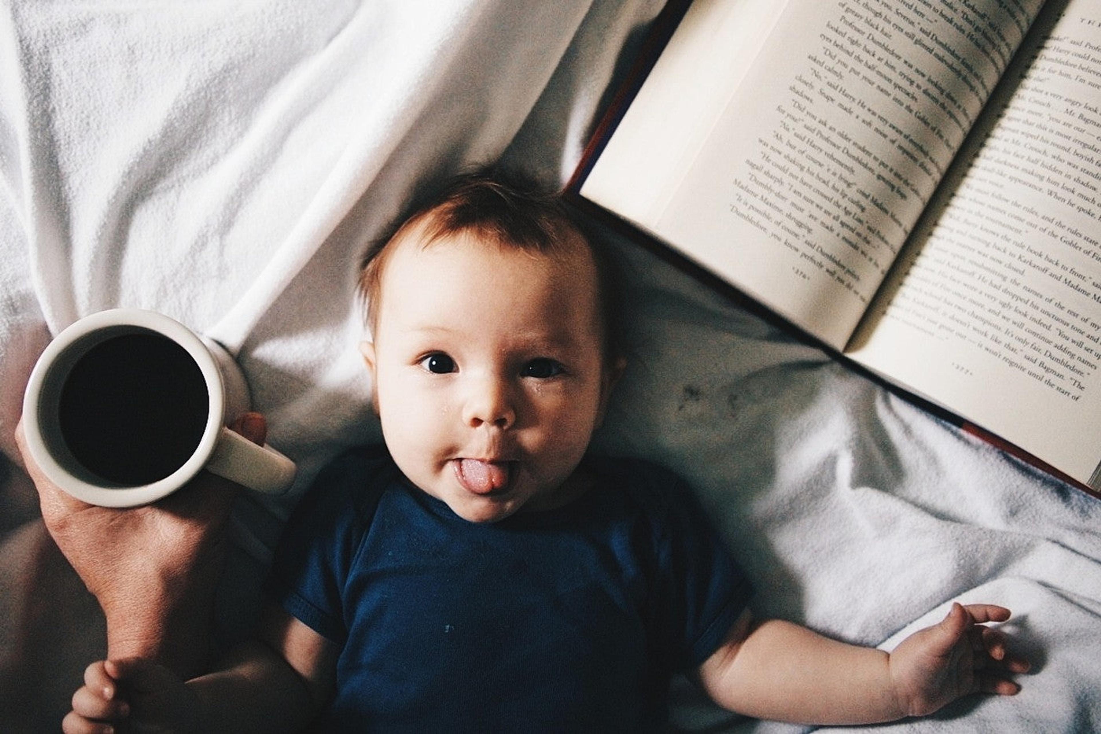 Literary baby names: Baby laying next to book