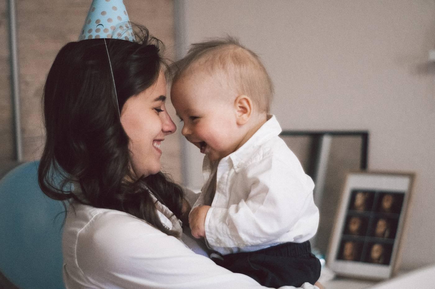 Mom in party hat with 1 year old