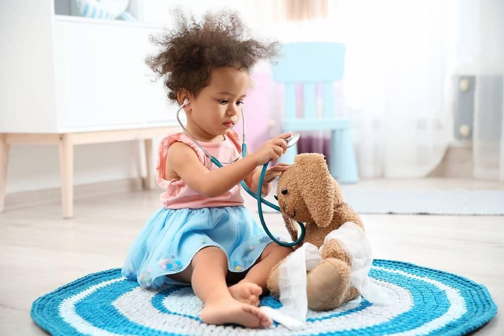 4-year-old playing doctor with stuffed animal toy
