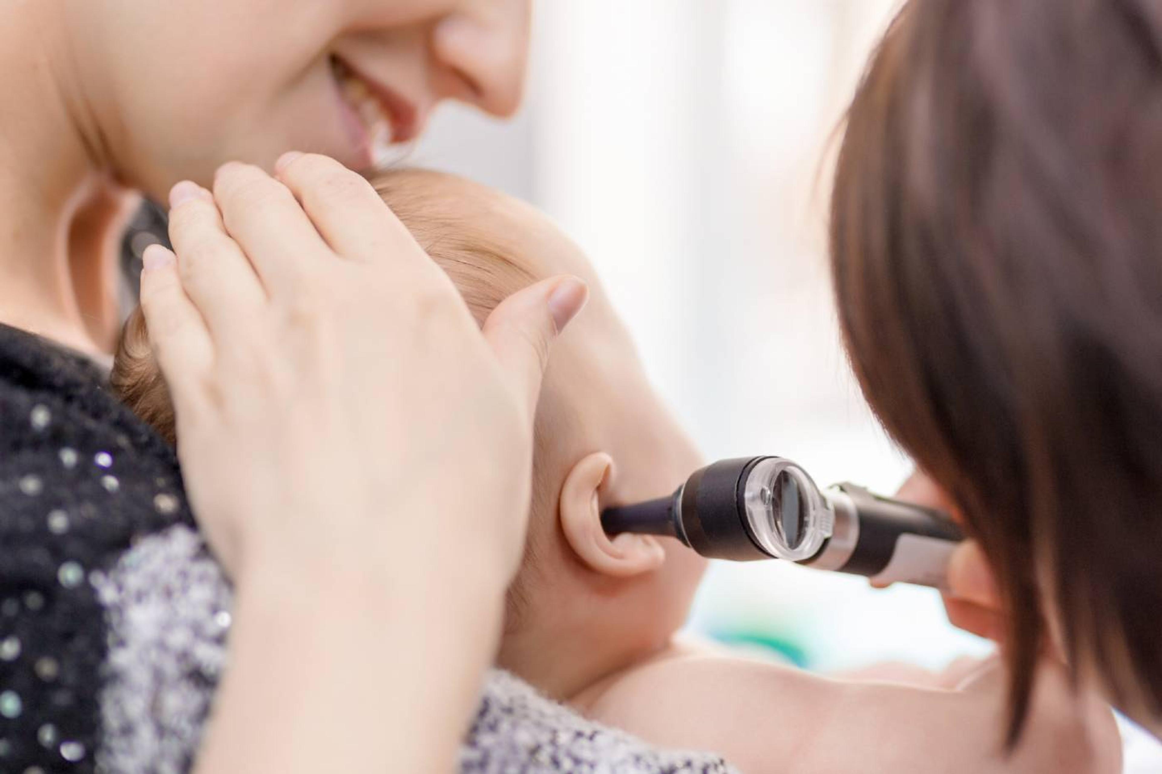 Baby with an ear infection getting examined by doctor