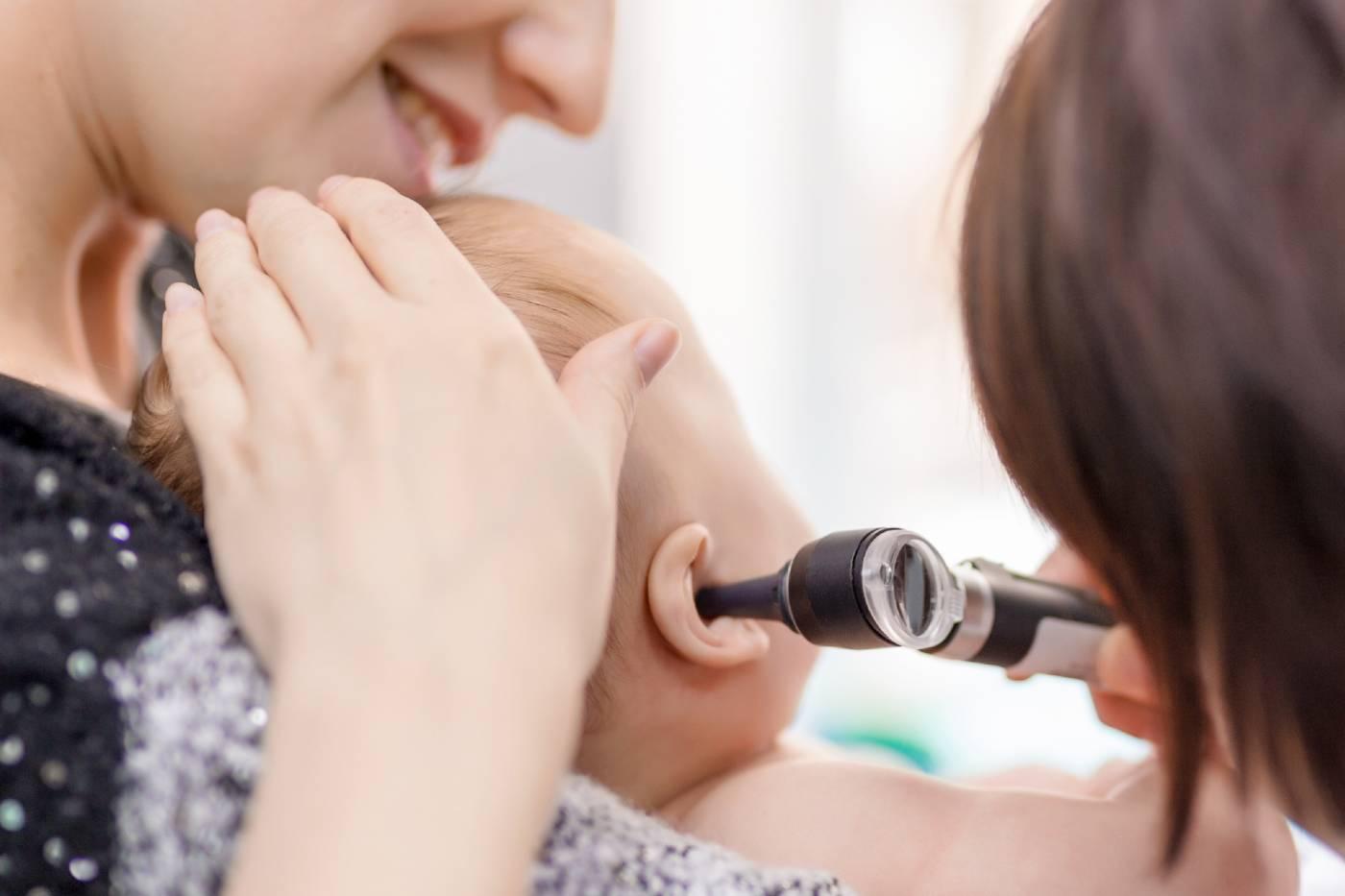 Baby with an ear infection getting examined by doctor