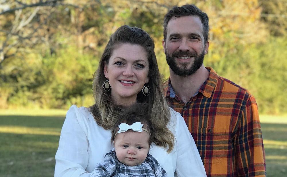 A mom and dad hold their newborn daughter