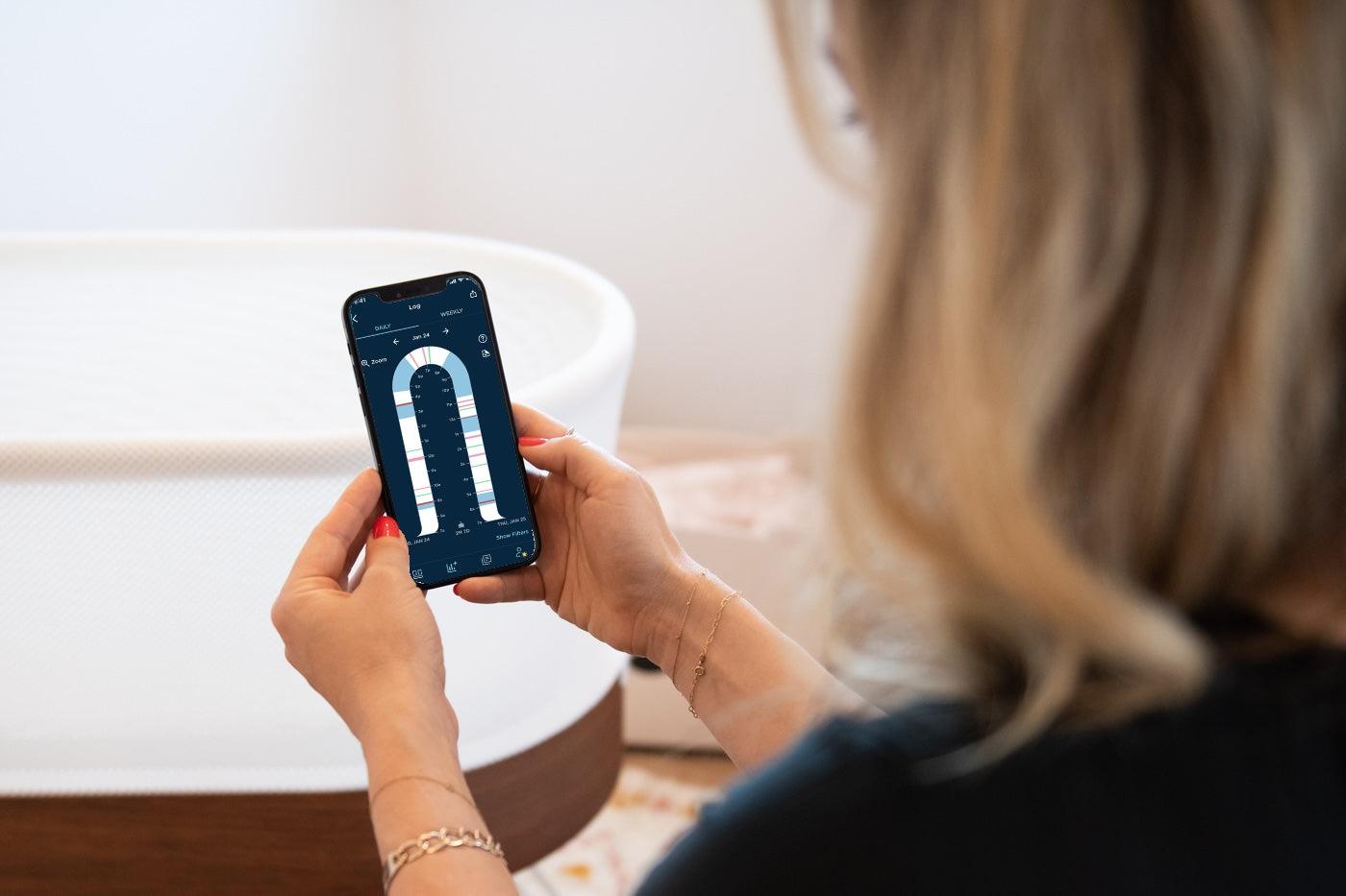 A mom uses the Happiest Baby App to look at her SNOO sleep log