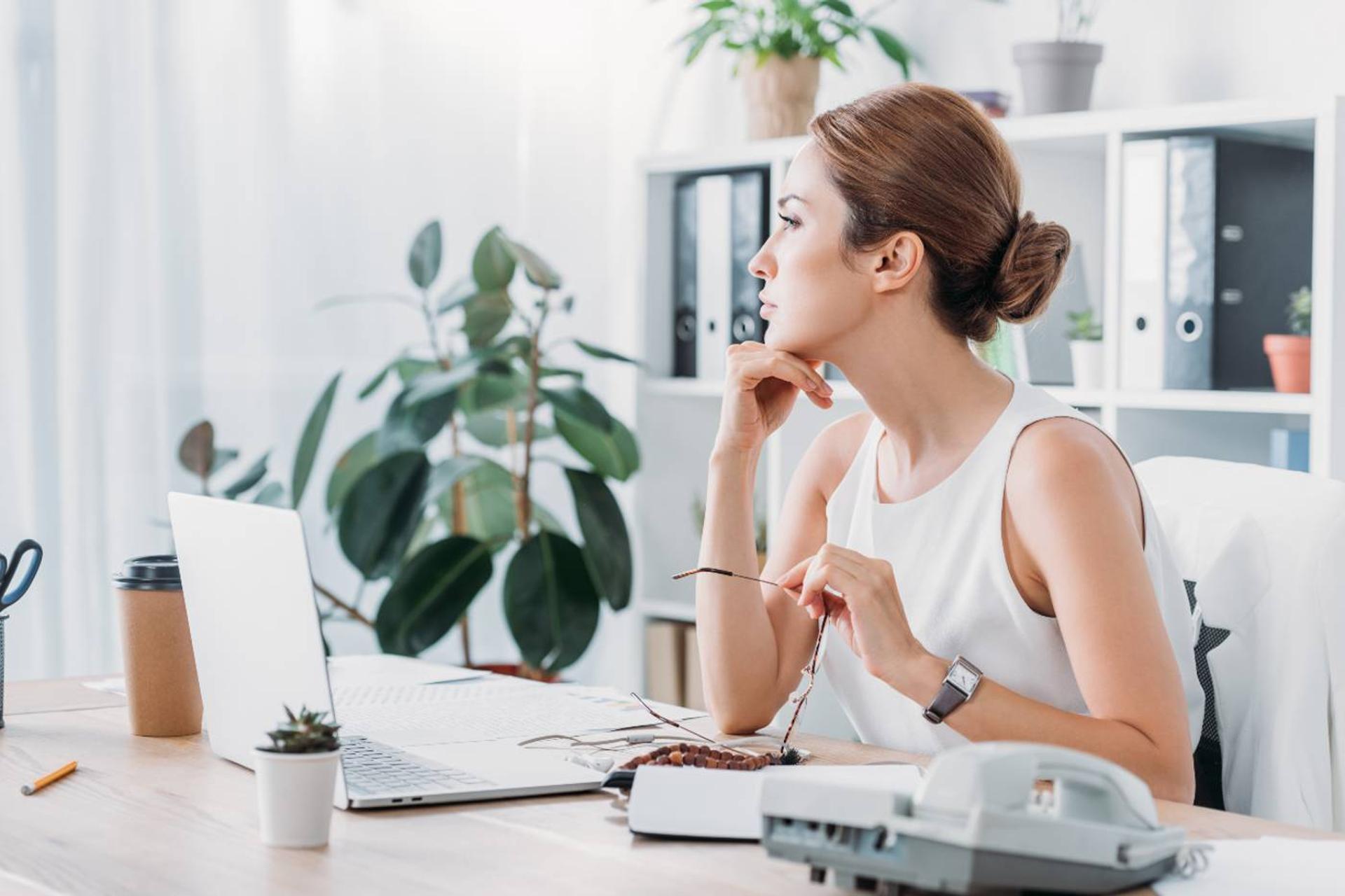 Woman at work thinking about telling boss she's pregnant