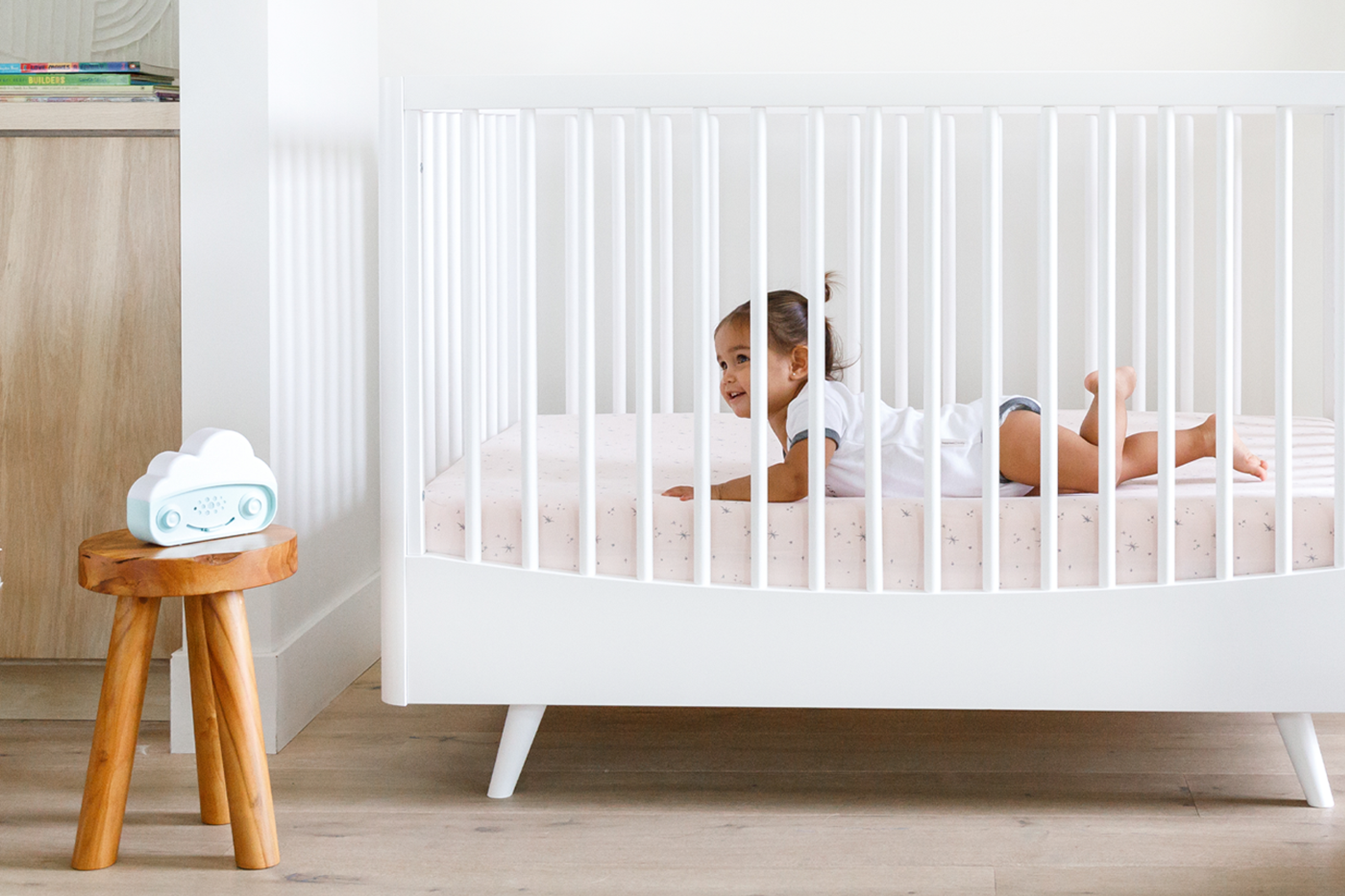 Toddler in crib listing to SNOObie white noise machine