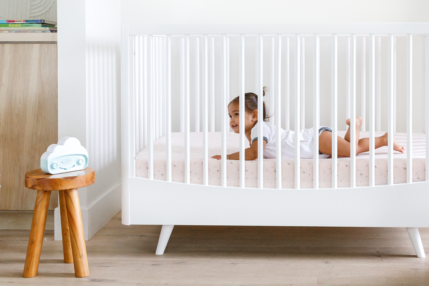 Toddler in crib listing to SNOObie white noise machine