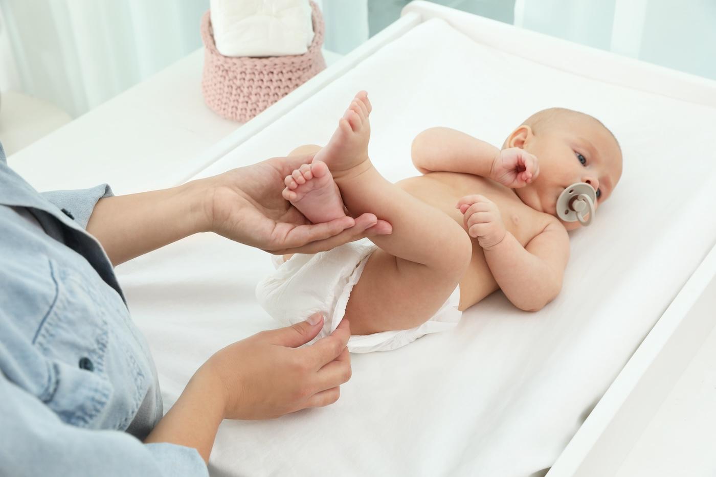 A parent changes a baby's diaper