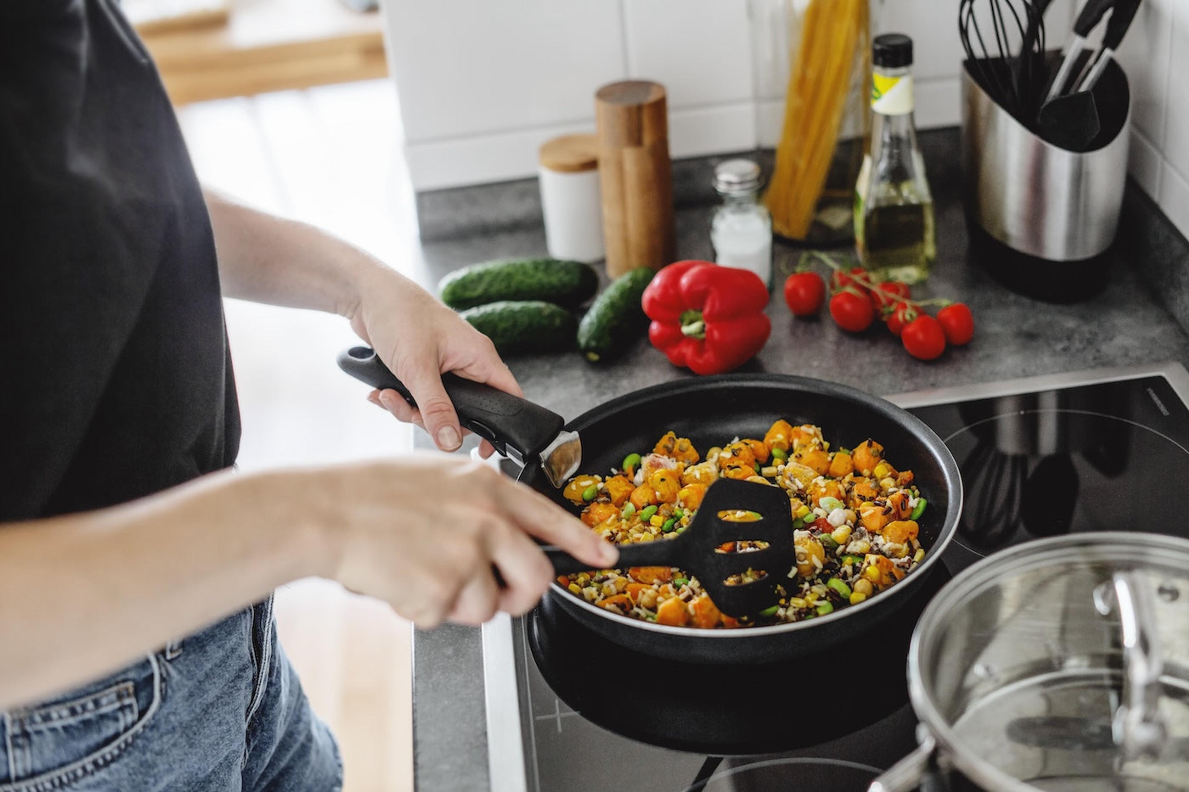 Woman cooking with black plastic spatula