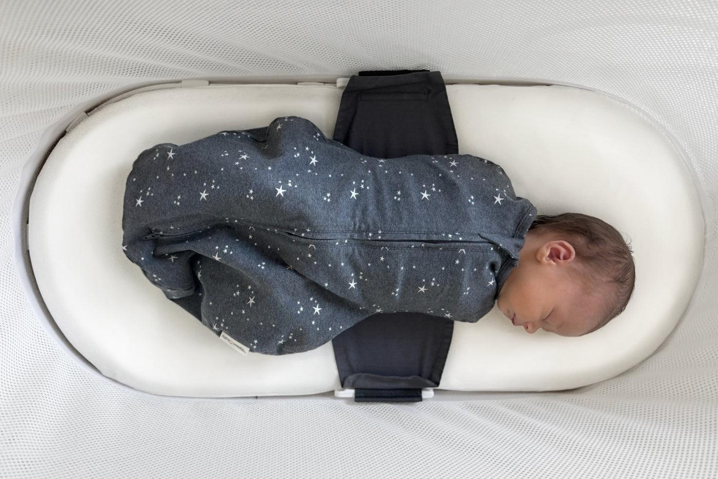 A baby sleeps in SNOO on a silk bassinet sheet