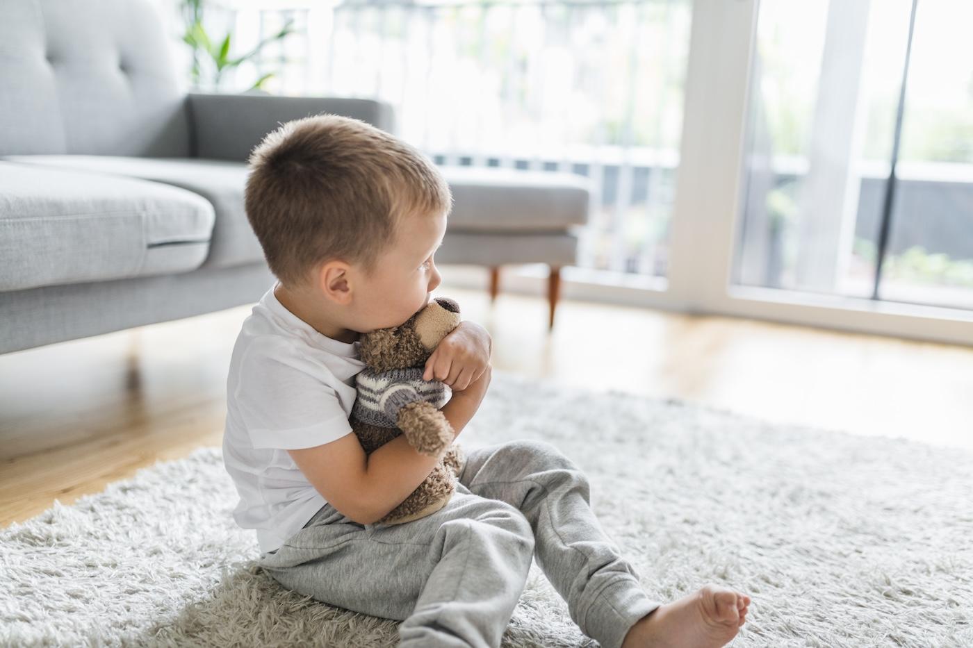 Toddler hugging teddy bear