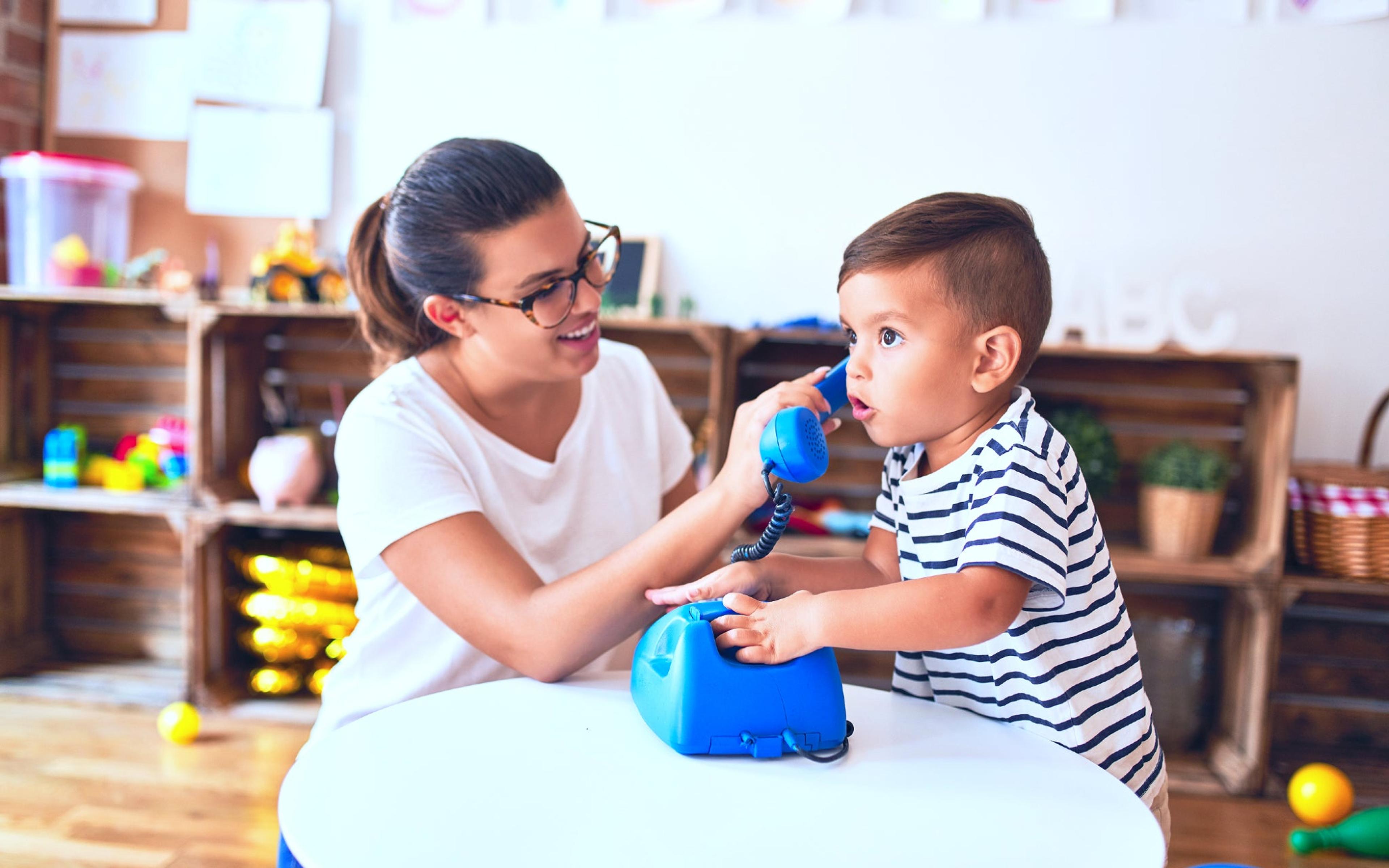 Woman and toddler playing with toy telephone to boost language skills