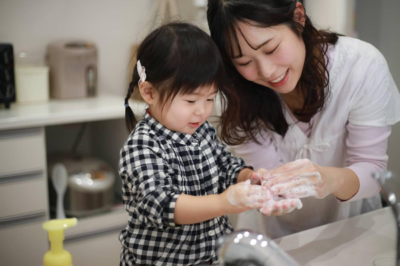 Mom teaching daughter to wash her hands
