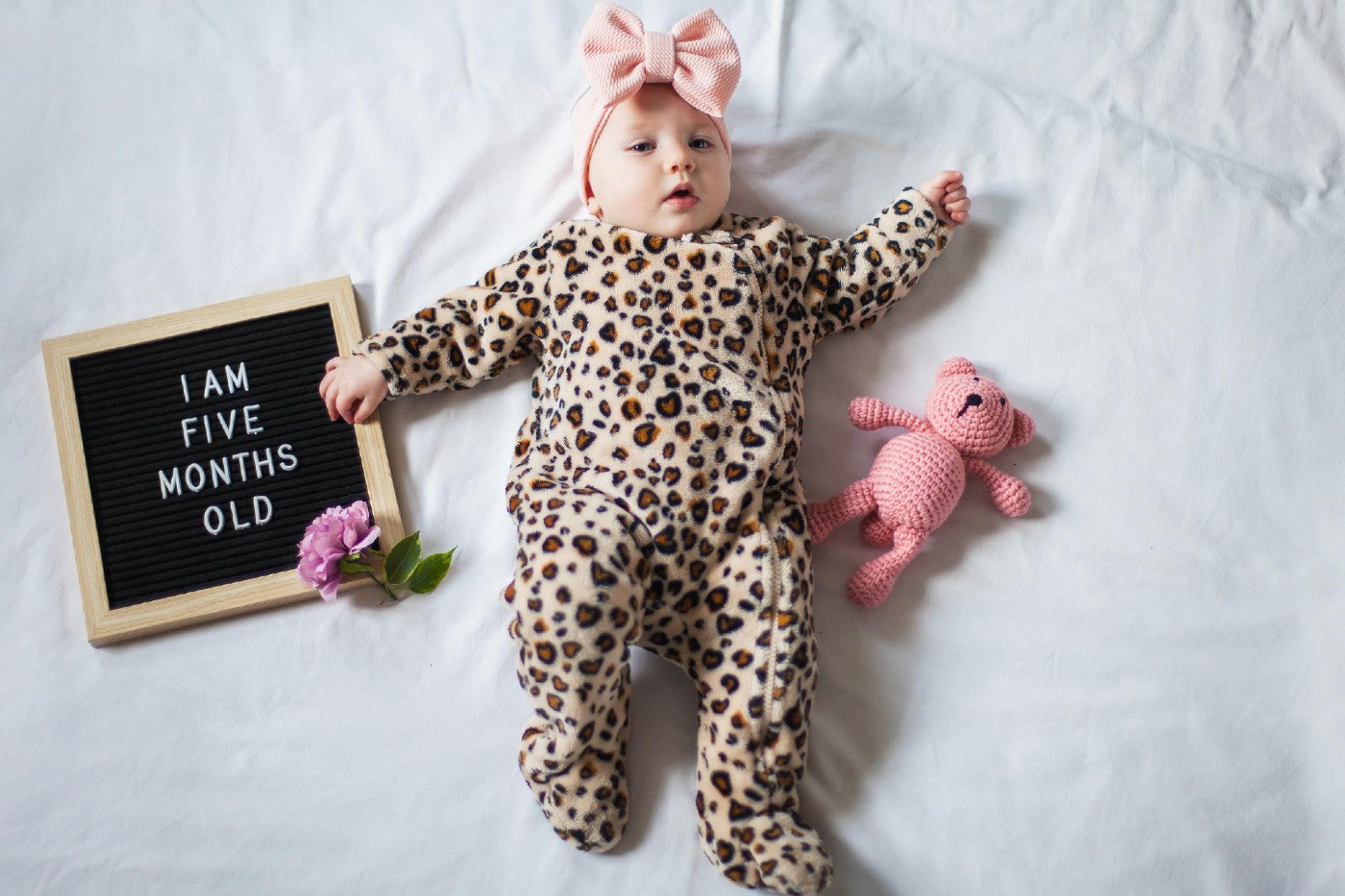Baby posing with letterboard that says "I am 5 months"