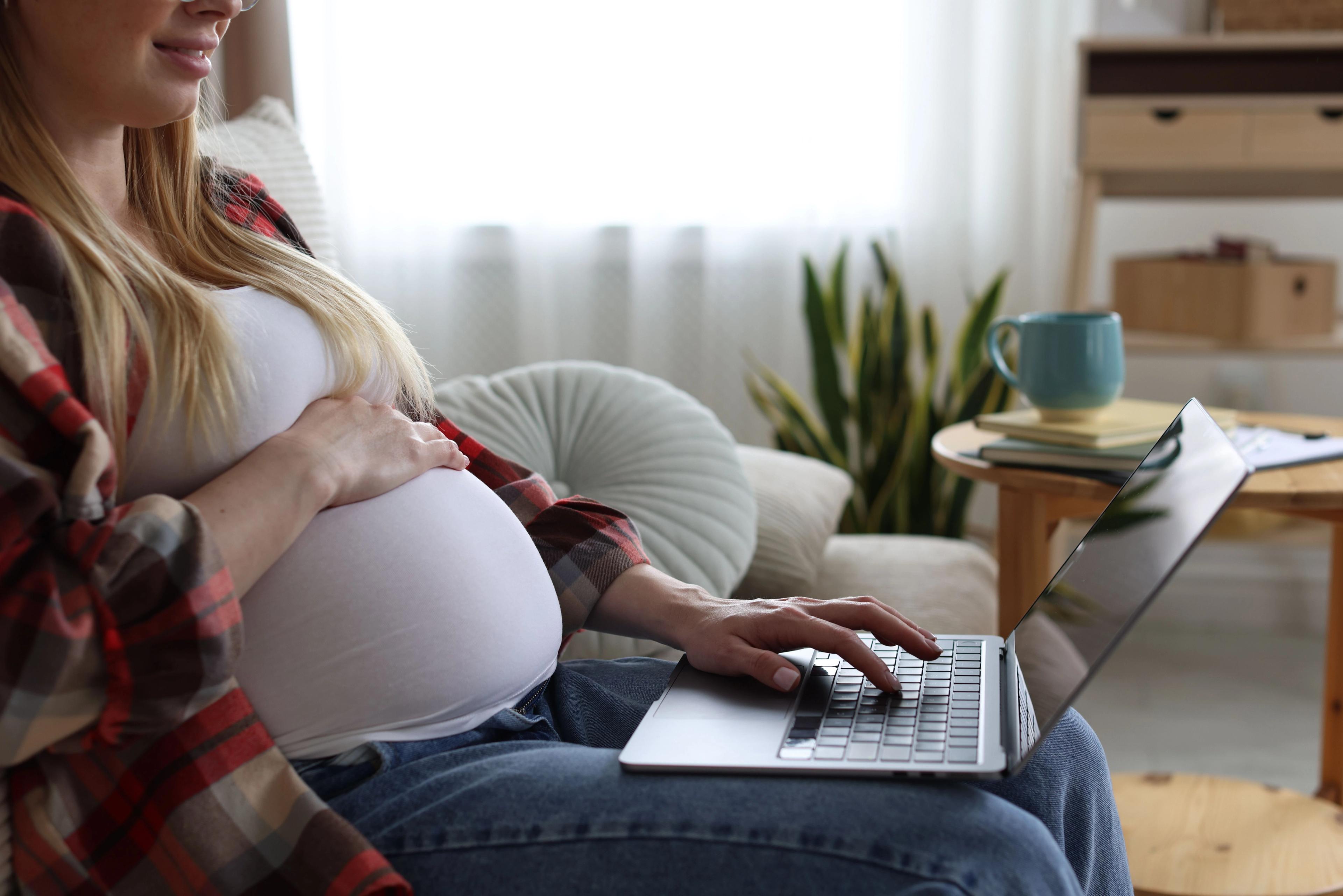 A pregnant woman researches health benefits during open enrollment