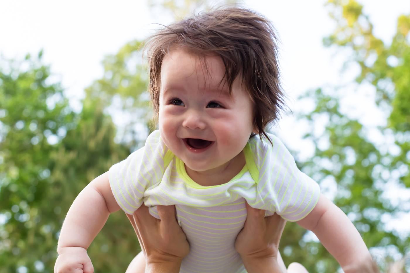 Smiling baby being held outdoors