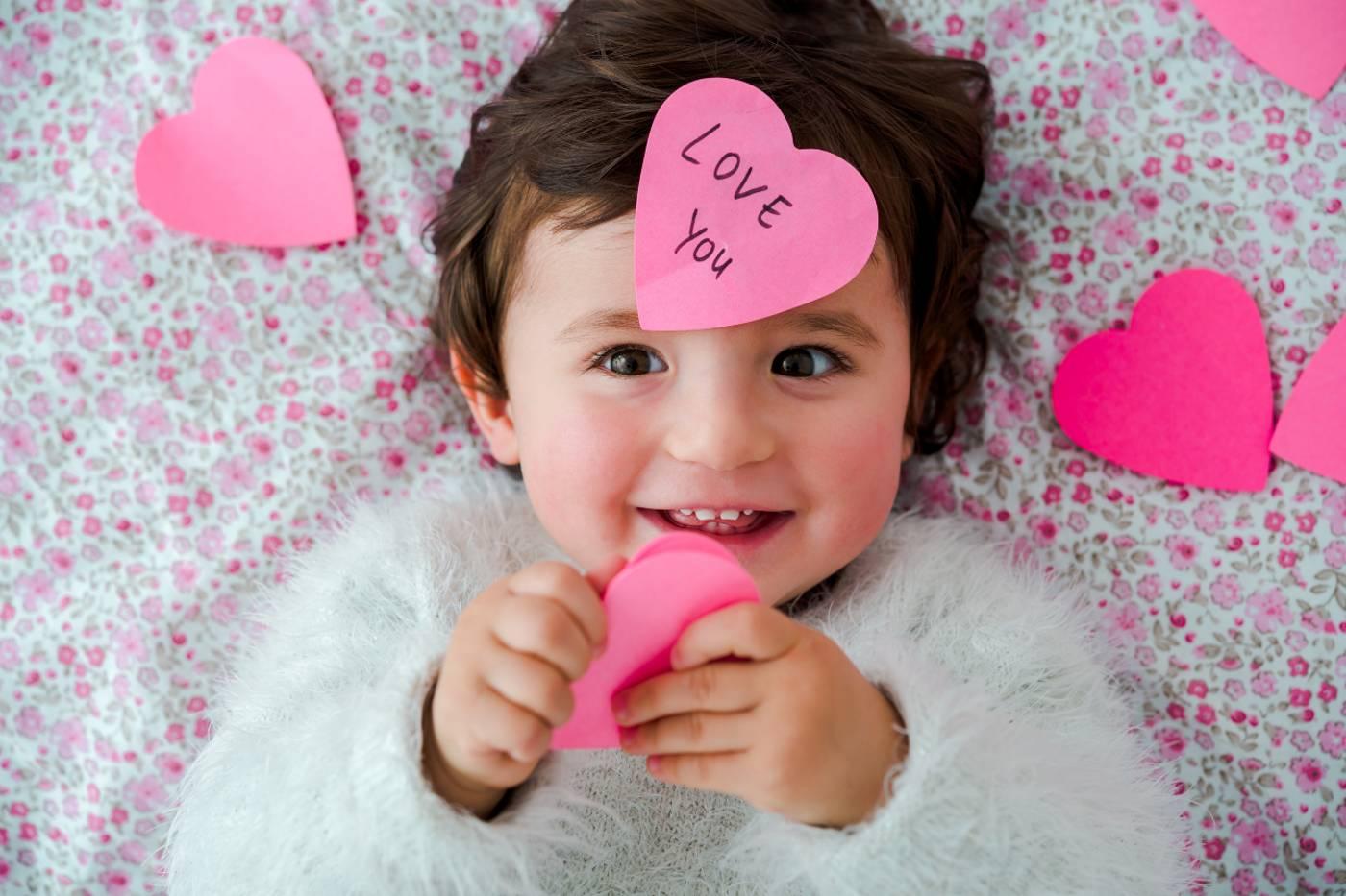 Toddler holding a heart-shaped paper craft