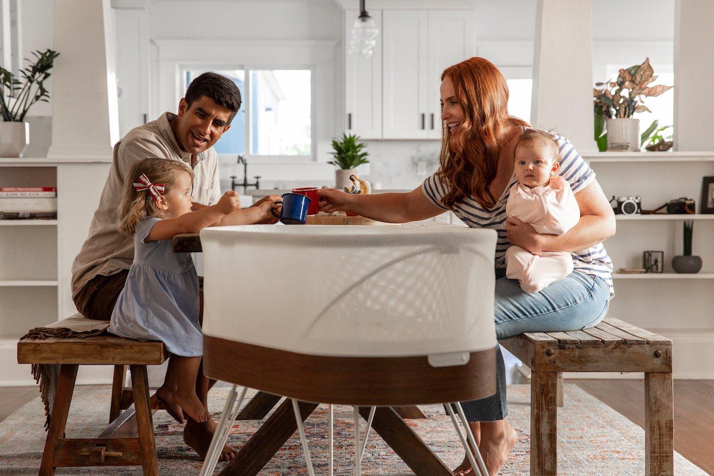mom-dad-kids-at-table-with-snoo-smart-sleeper