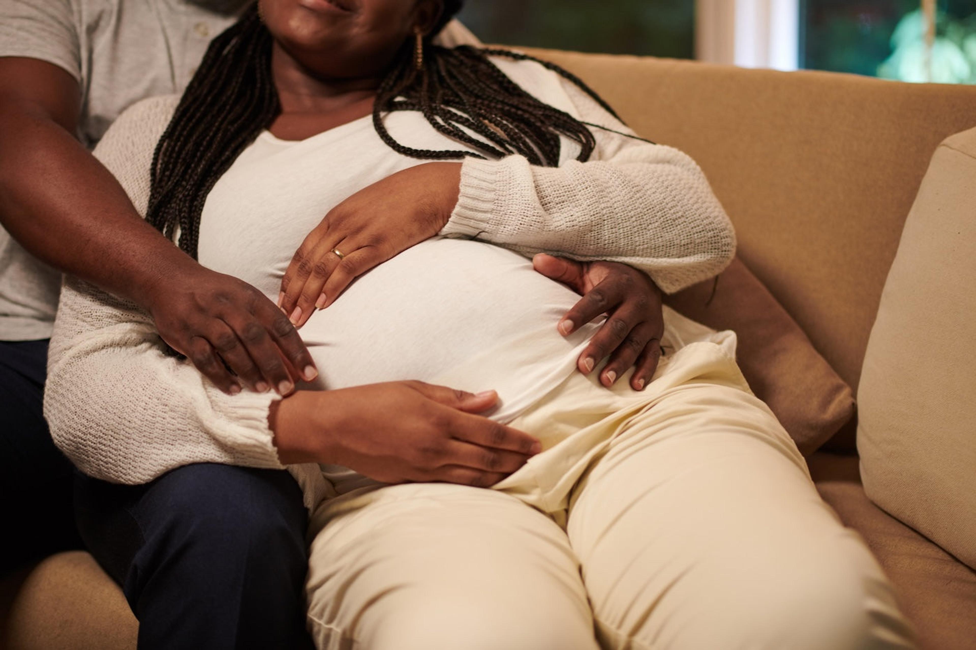 A Black man cuddles his pregnant wife