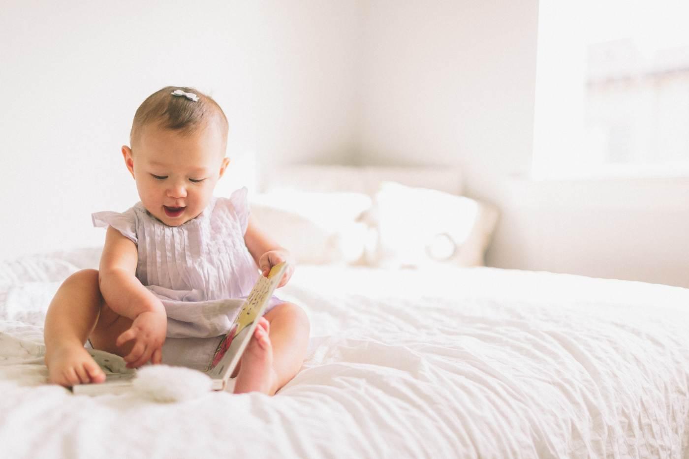baby girl with a rare baby name sitting on a bed