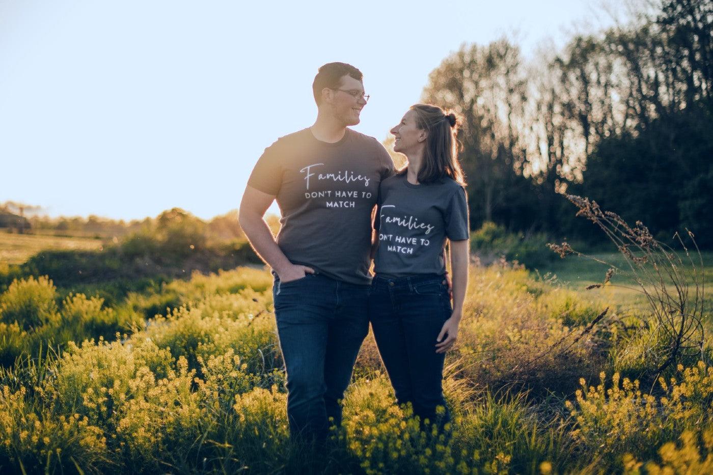 Couple wears shirts that read "Families don't have to match" to announce adoption