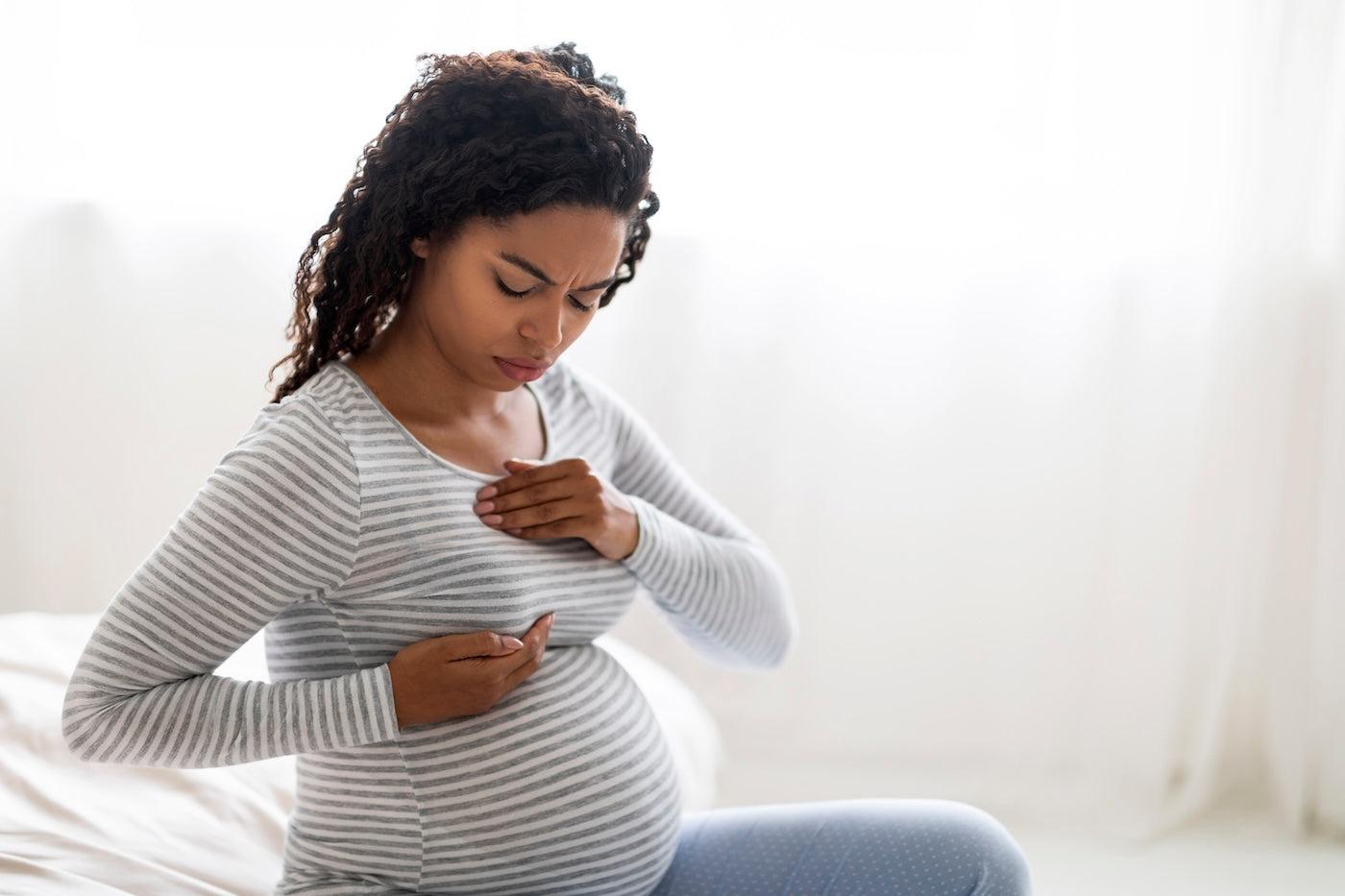 A pregnant woman experiencing breast discomfort