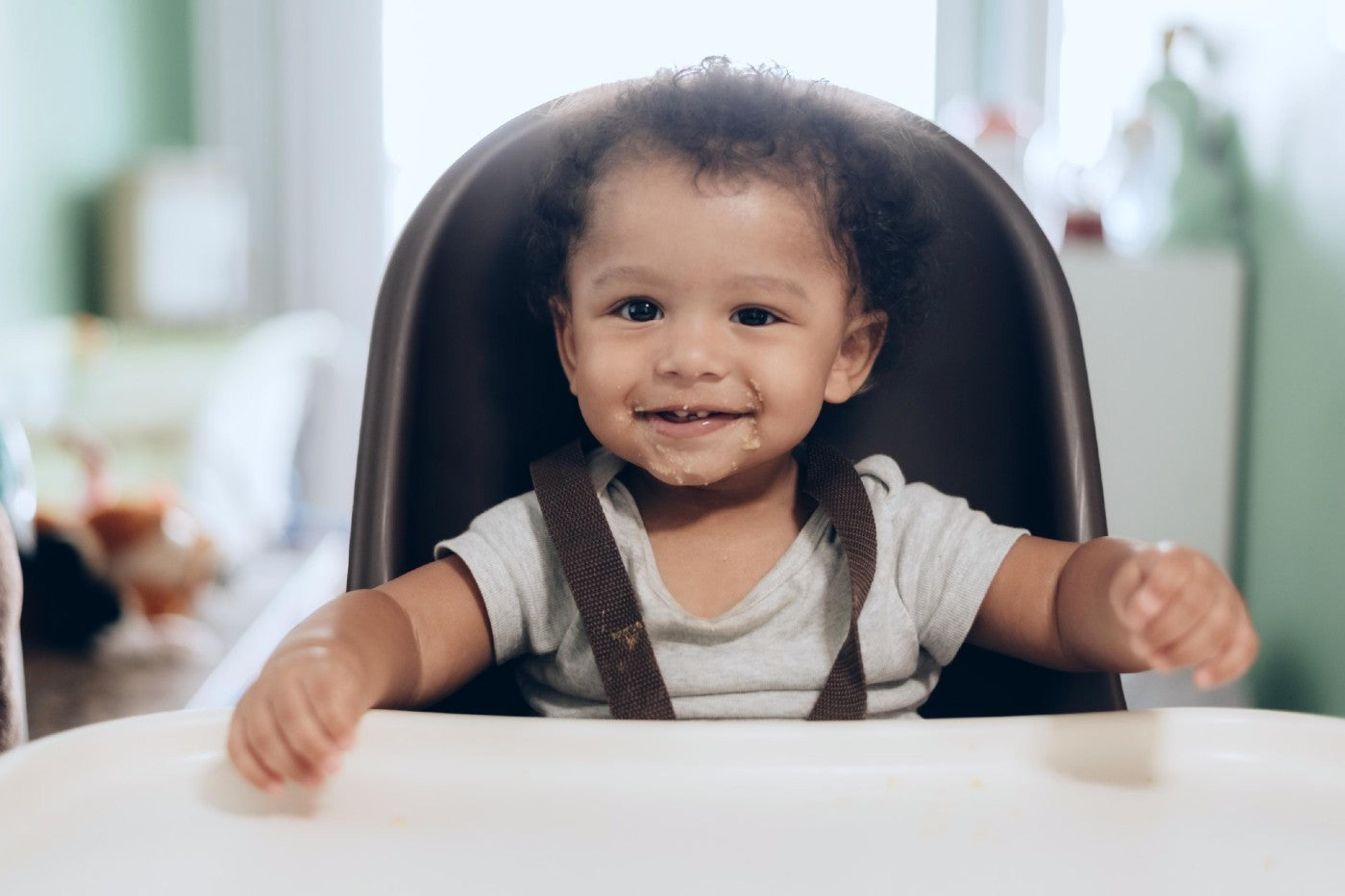 Baby smiles from high chair