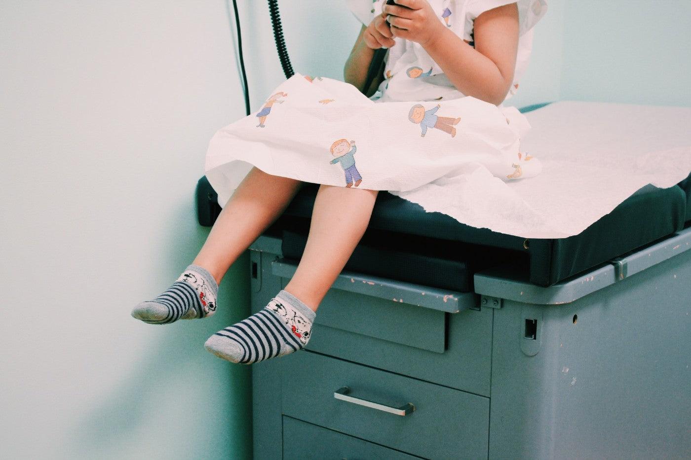 Child sits on doctor's exam table
