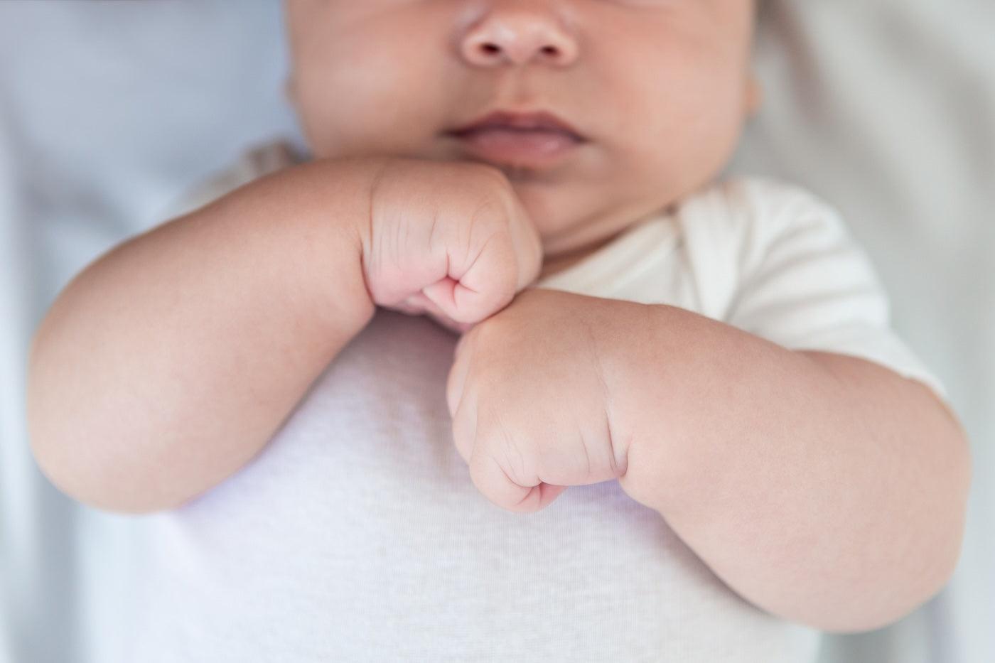 A baby with clenched fists