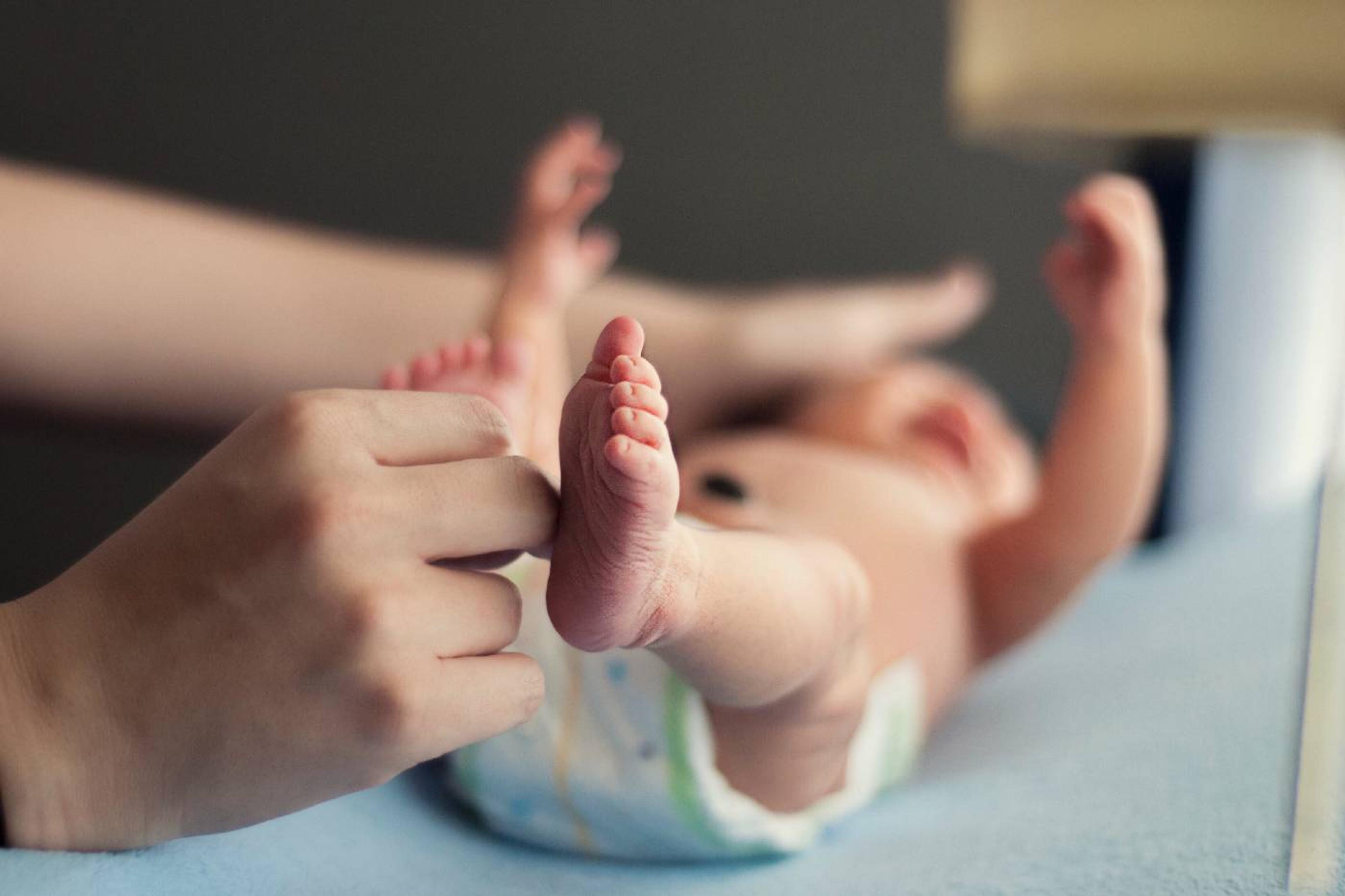 parent changing newborn in diaper first poop