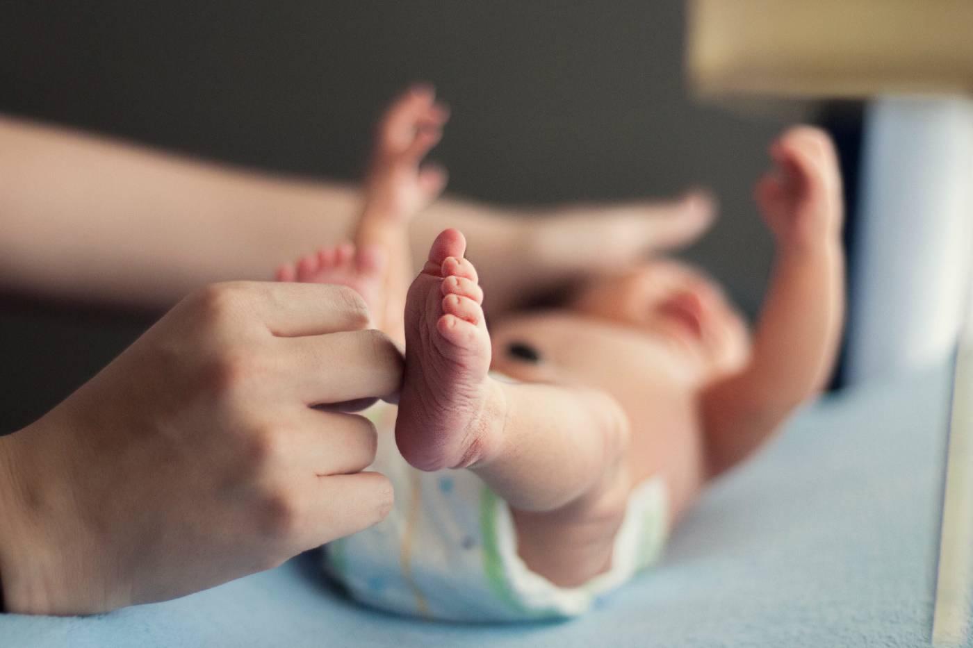 parent changing newborn in diaper first poop