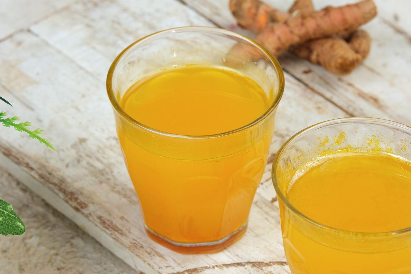 Two glasses of turmeric juice on a table