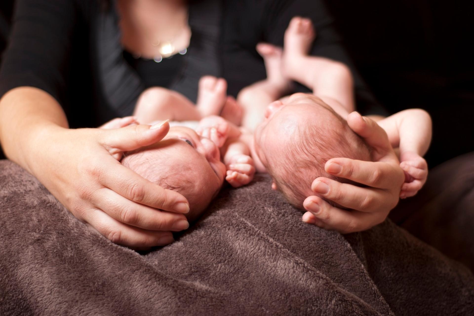 A new mom holds newborn twins