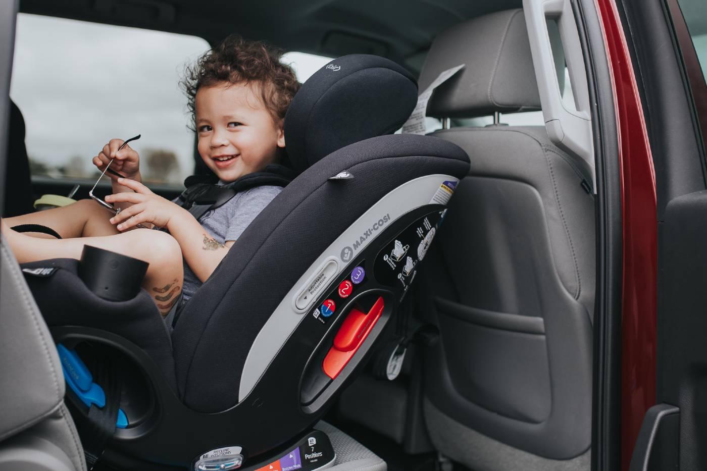 Smiling toddler in a rear-facing car seat