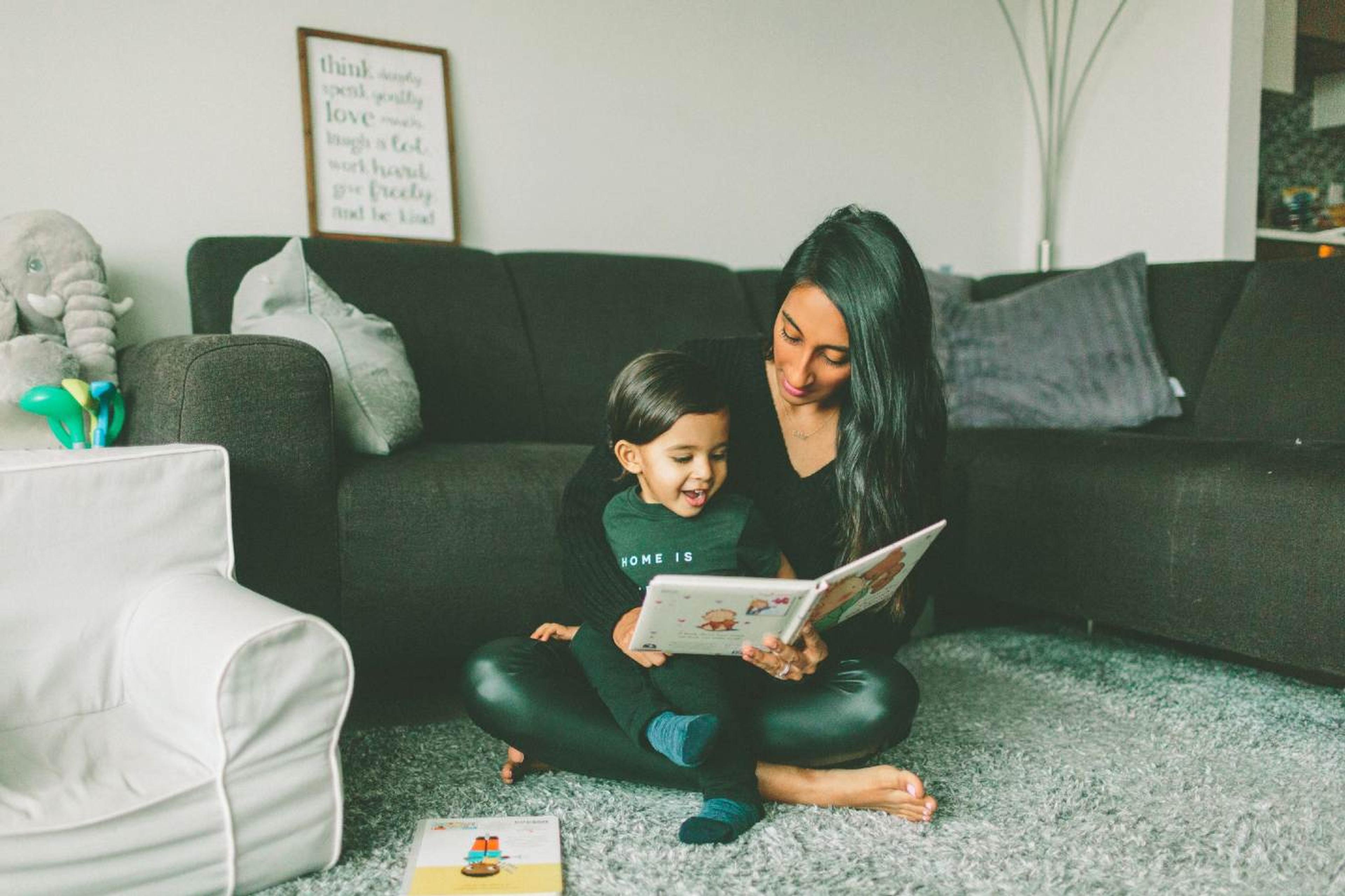 Children's Books in French - mother reading a picture book to toddler son on the carpet