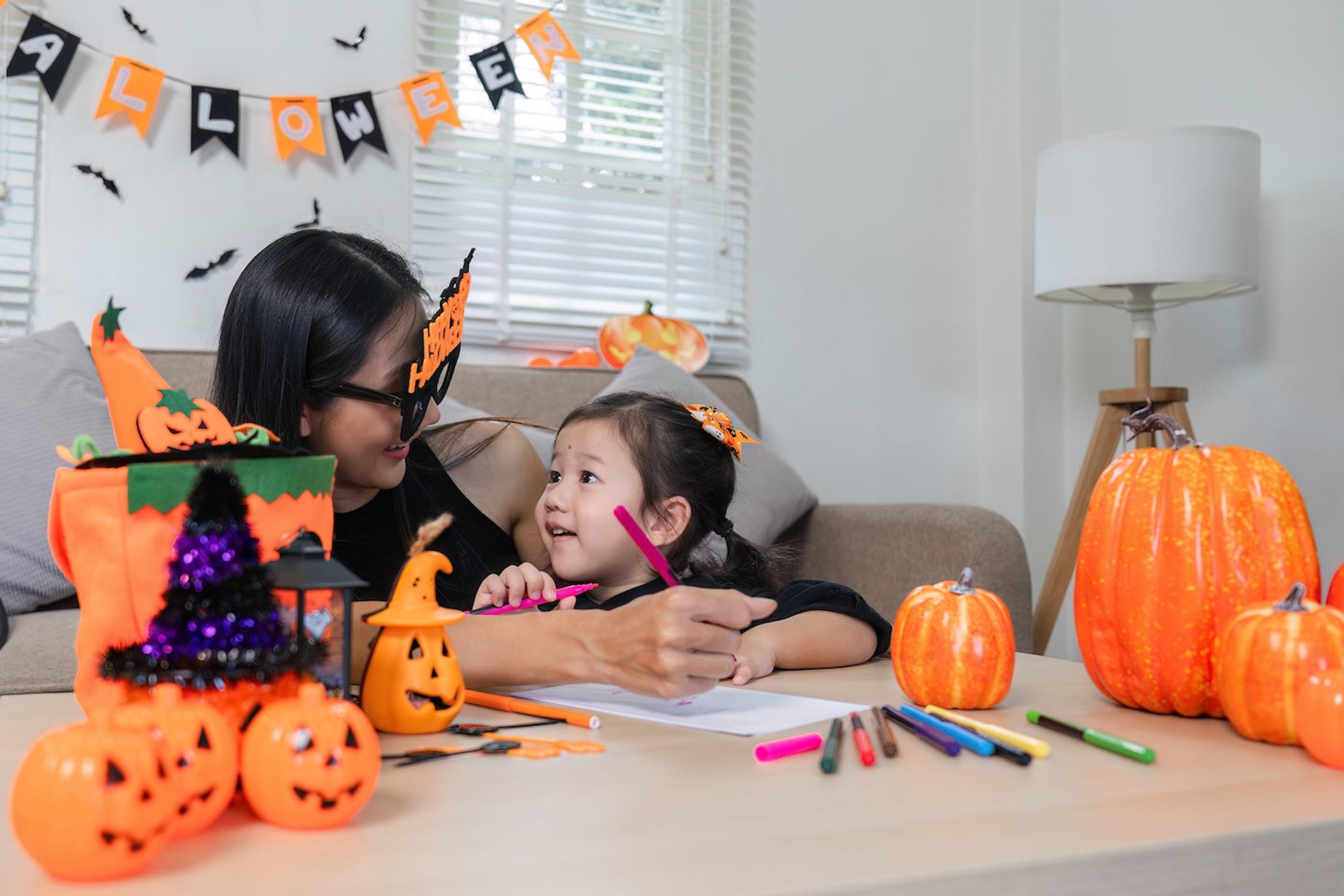 Mother and toddler daughter work on a Halloween worksheet together