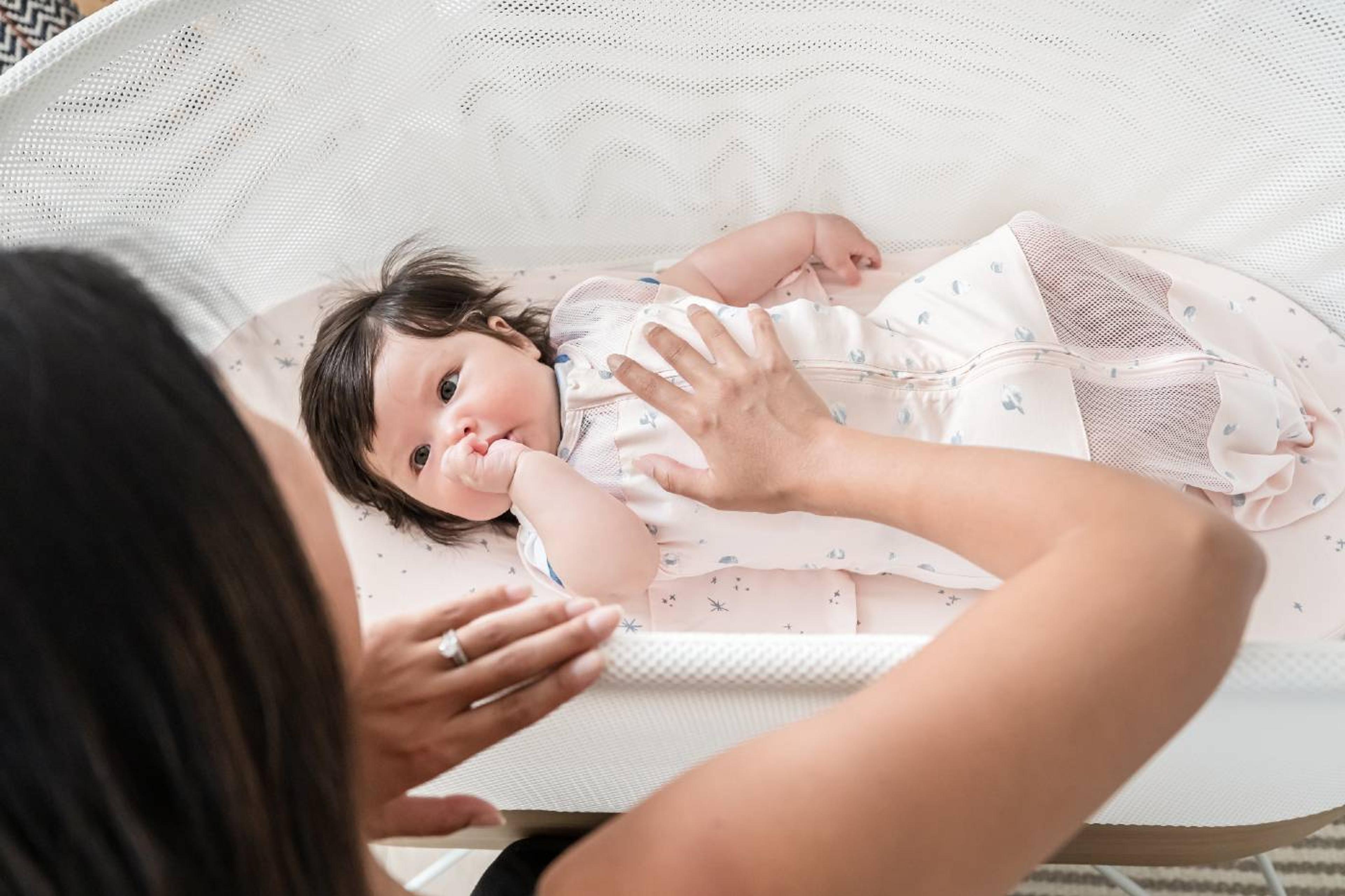 mom helping baby in SNOO with bedtime routine