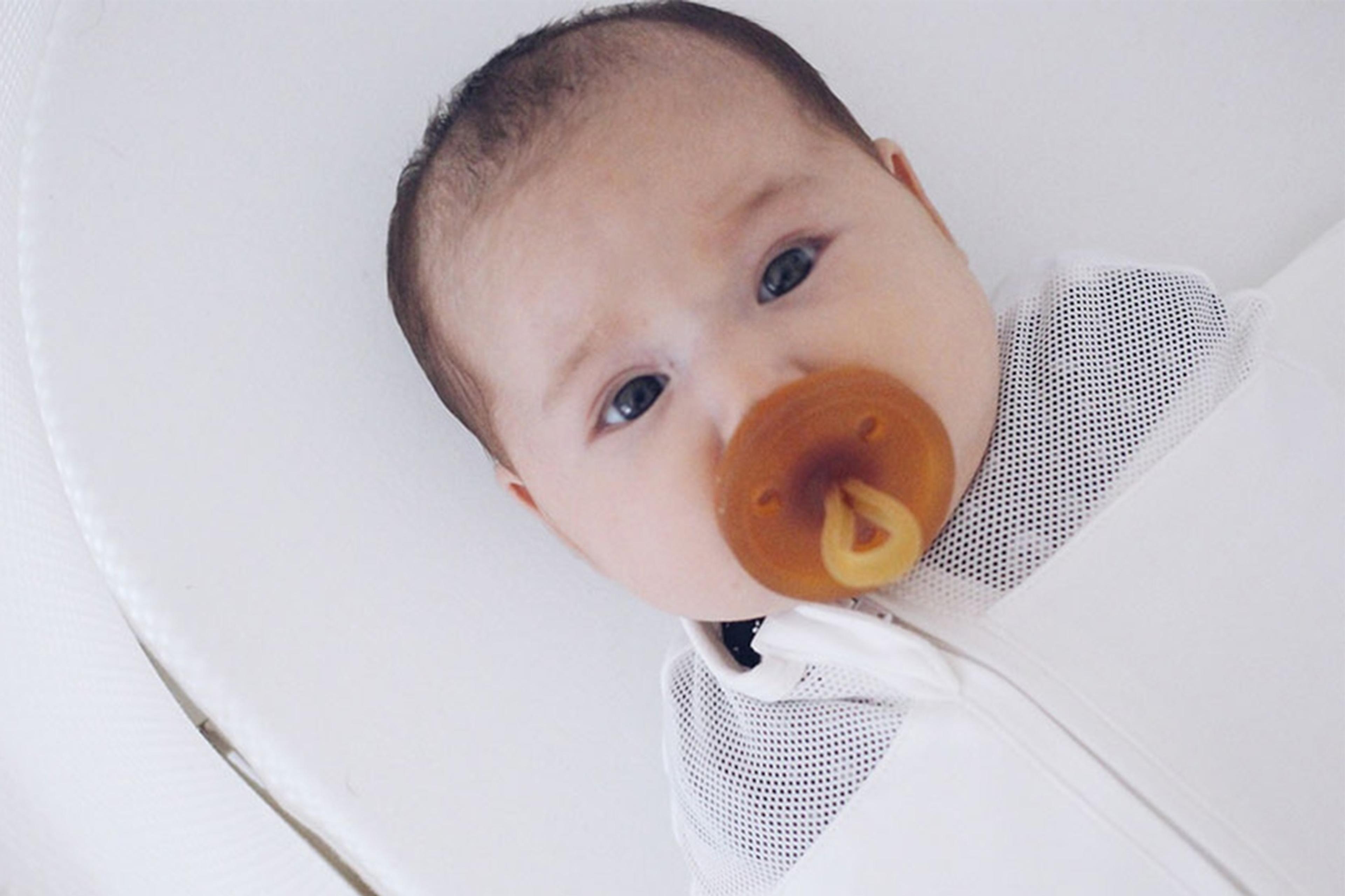 A baby sucks on a pacifier