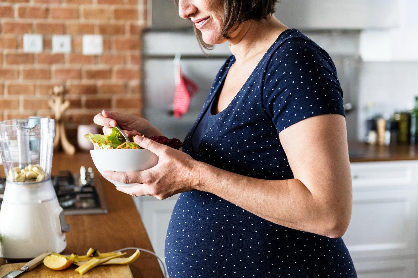 Pregnant woman eats a salad