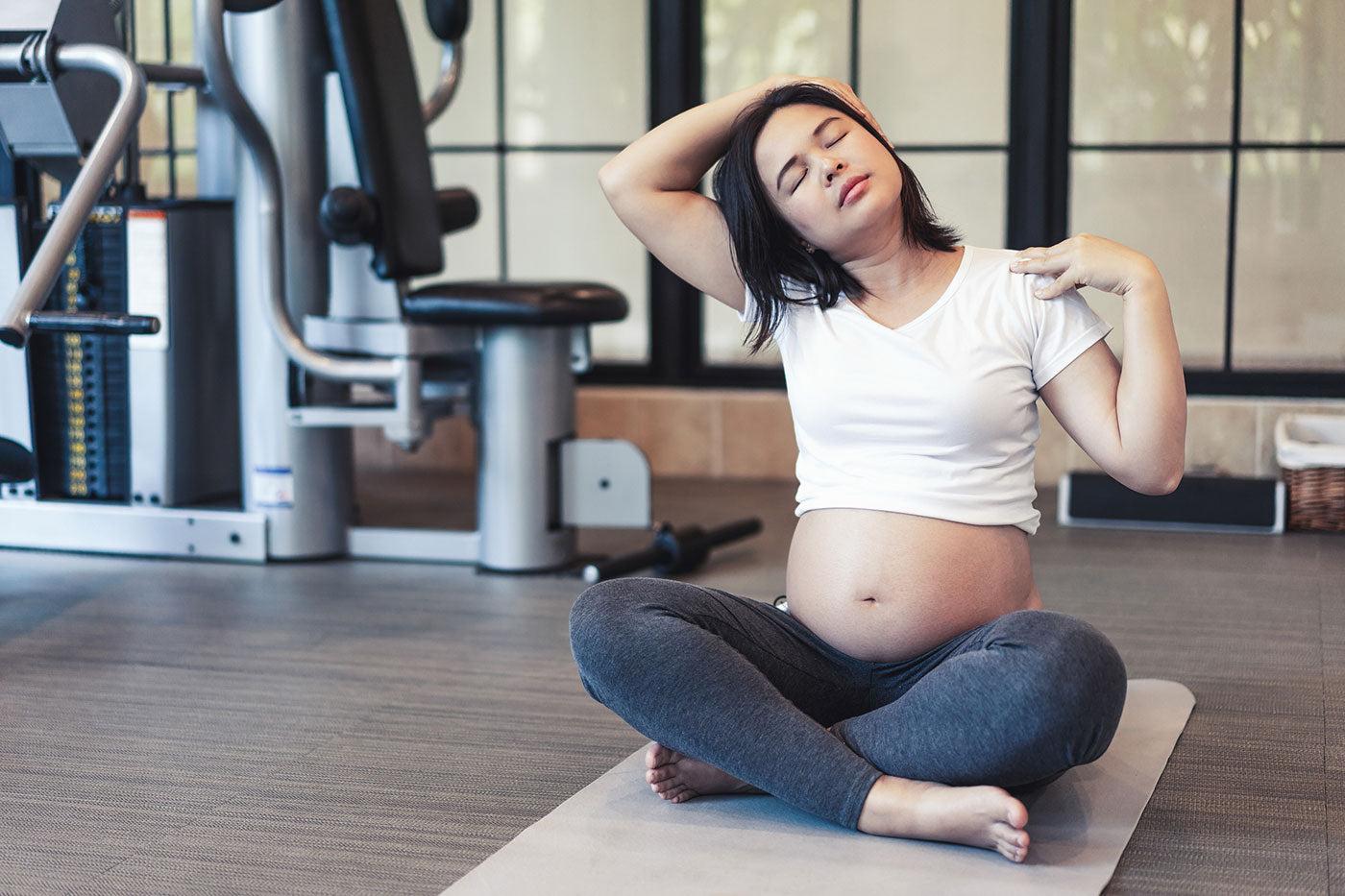 pregnant-mom-stretching-at-the-gym
