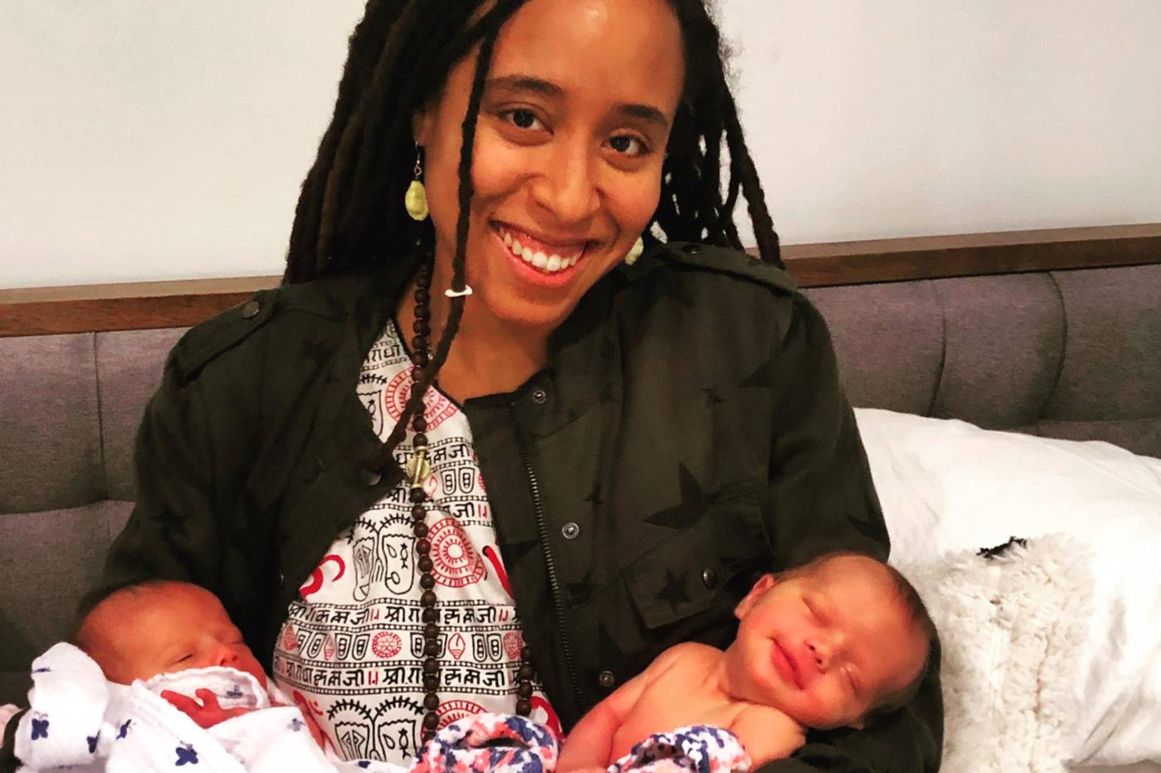 Bailey Rollins, a Boober lactation consultant, holding two infants