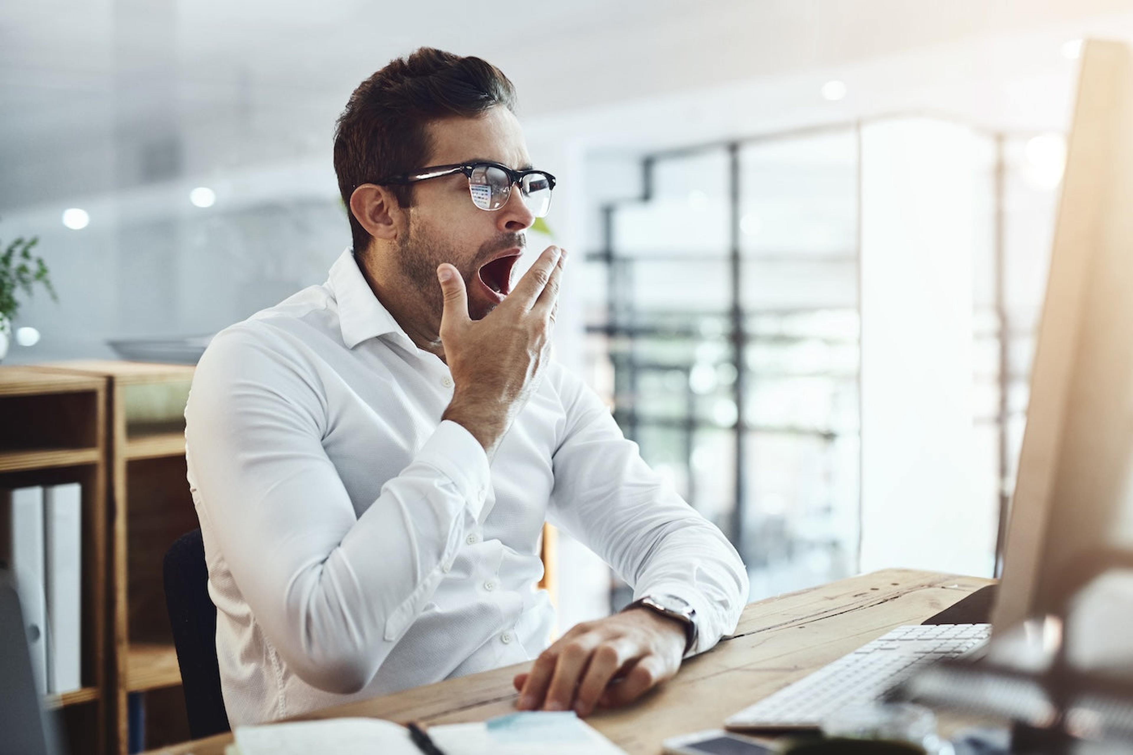 A man yawns at work
