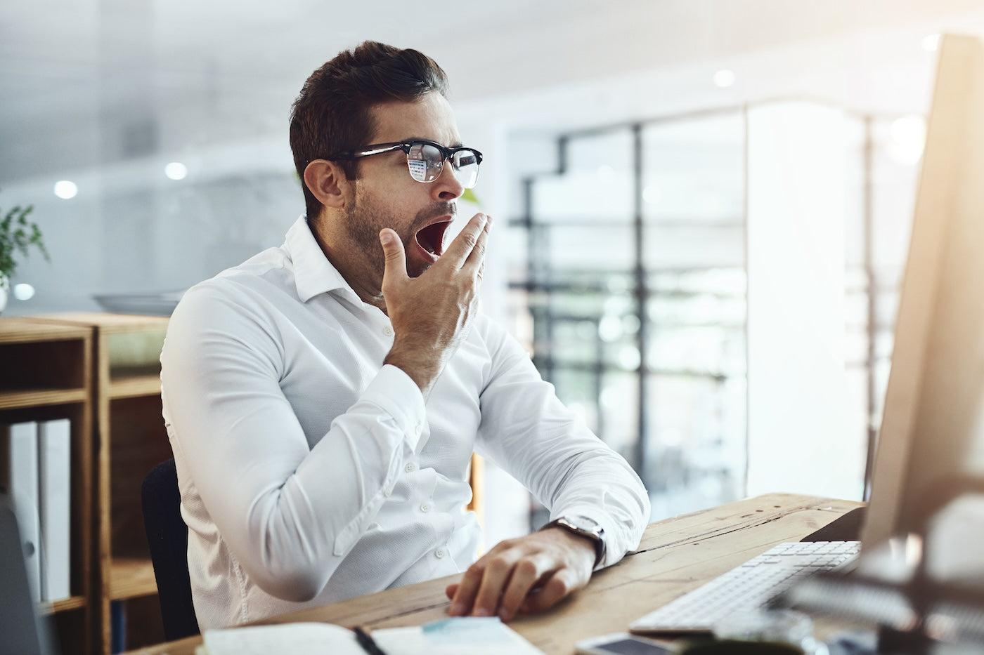 A man yawns at work