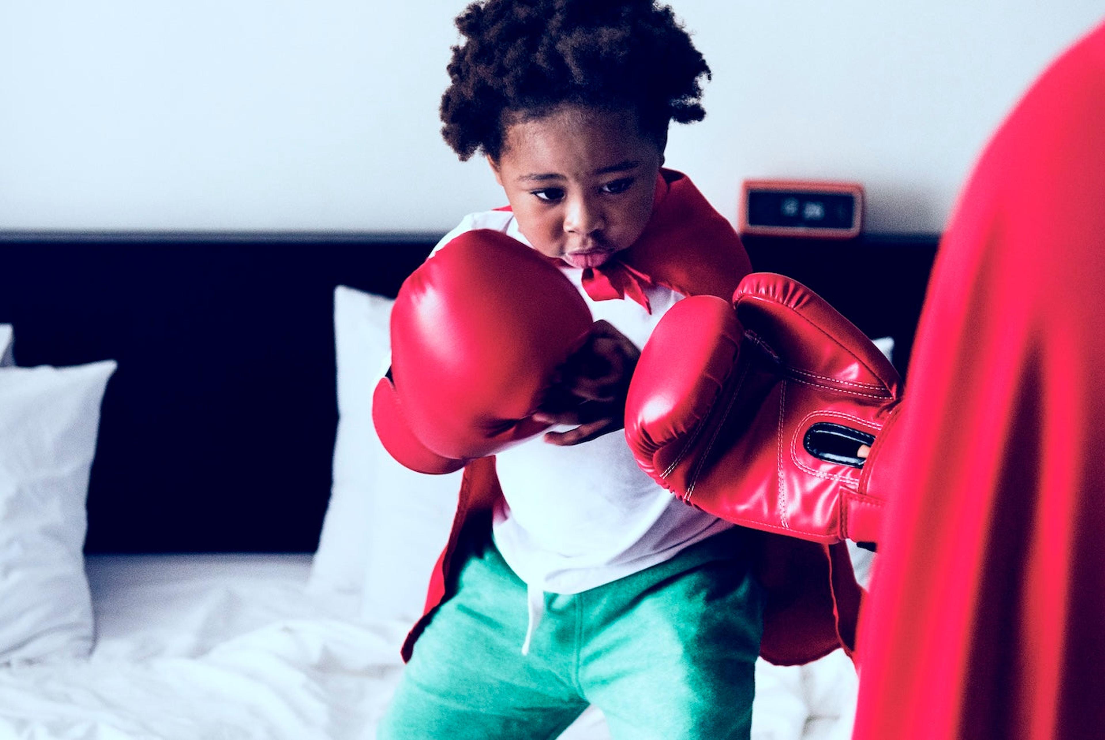 Toddler boy wearing boxing gloves